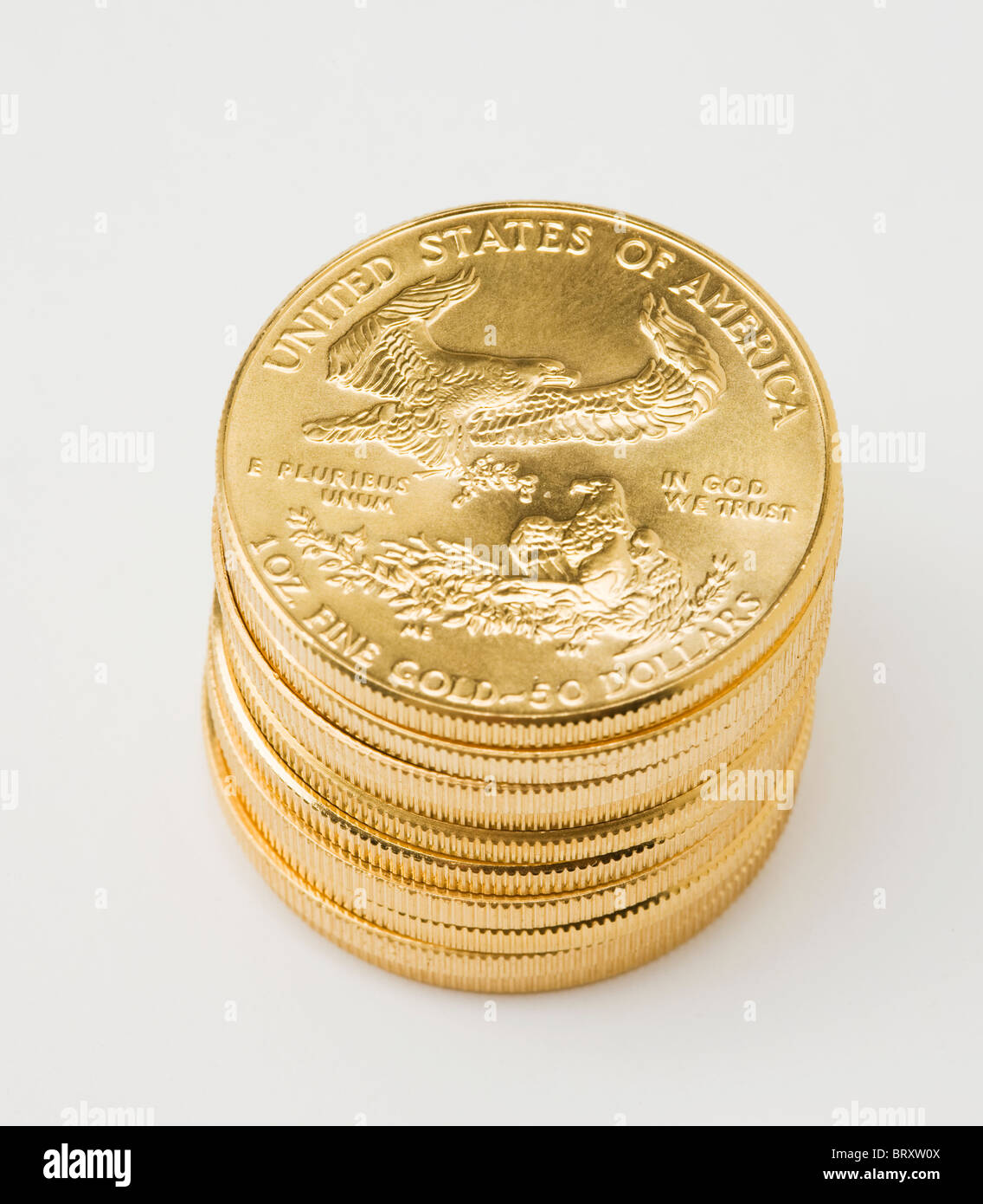 Pila de monedas estadounidenses de oro sobre fondo blanco. Foto de stock