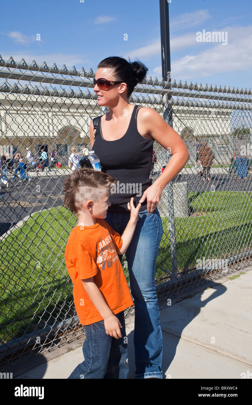 Una madre y un joven con un corte de pelo divertido en una escuela en Salida de California Foto de stock