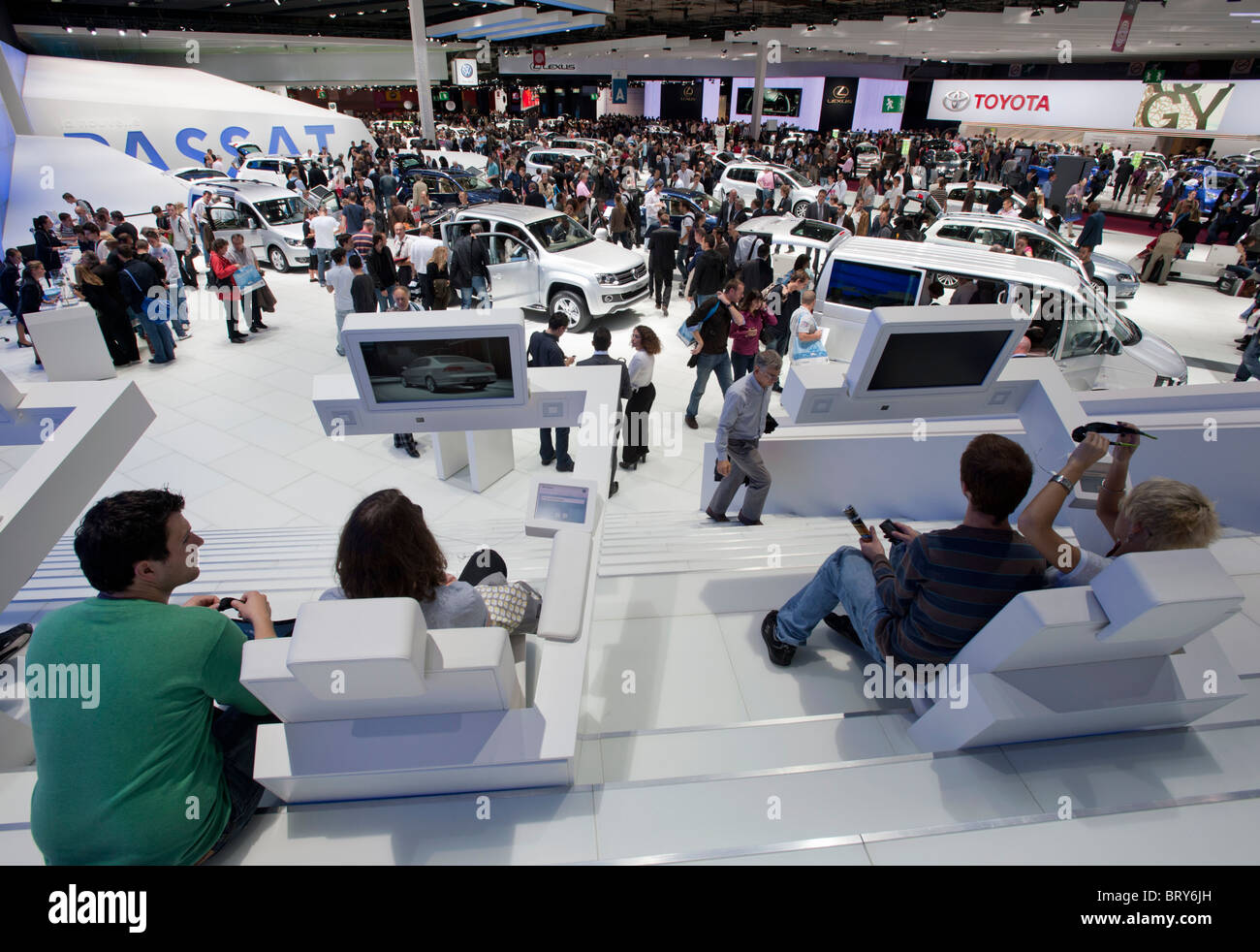 Los visitantes que utilizan los televisores 3D y la vista de la ajetreada hall en Paris Motor Show 2010 Foto de stock