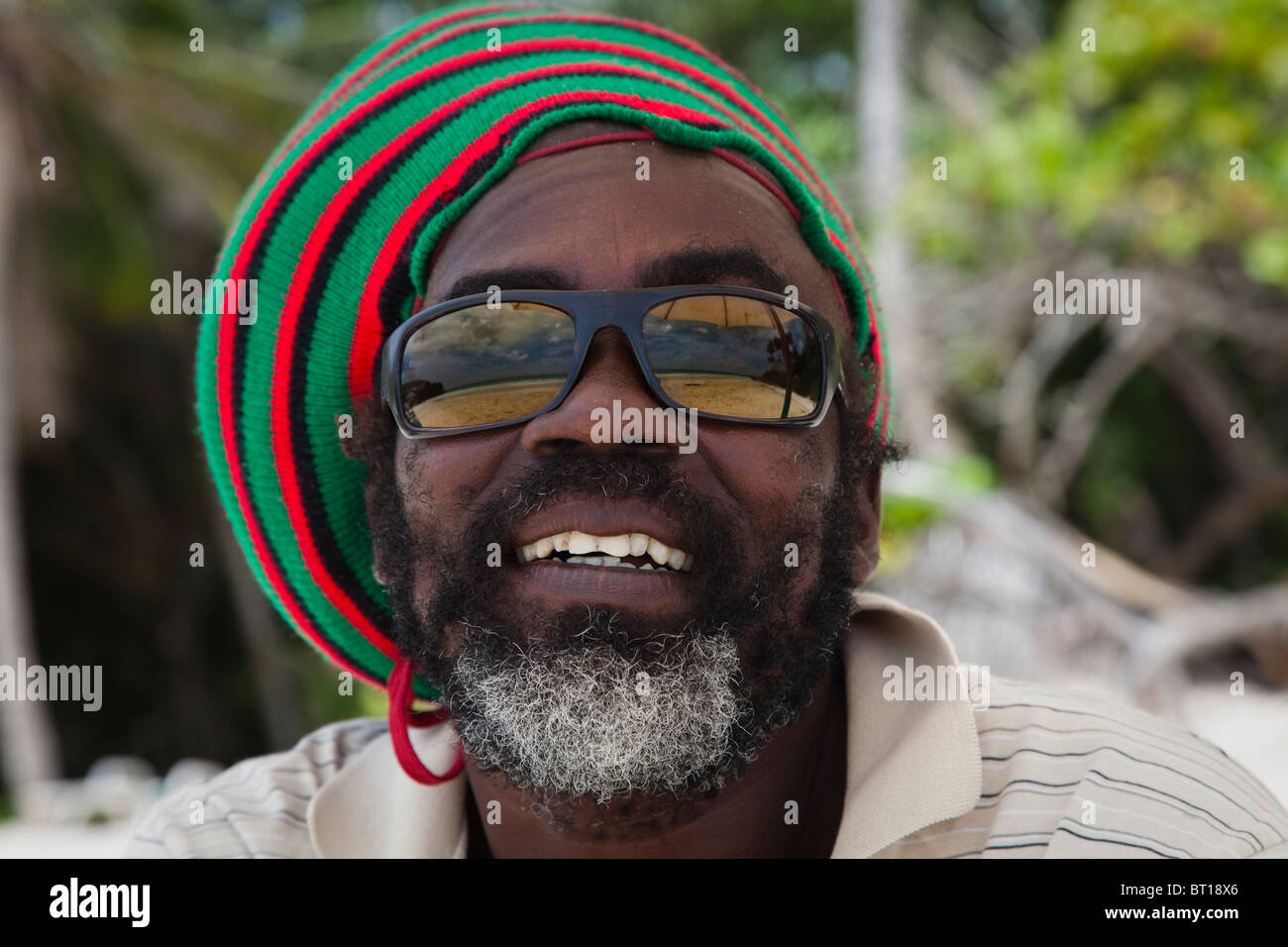 Hombre Negro en una playa en Barbados, Indias Occidentales, con gafas de  sol reflejando el Caribe Fotografía de stock - Alamy