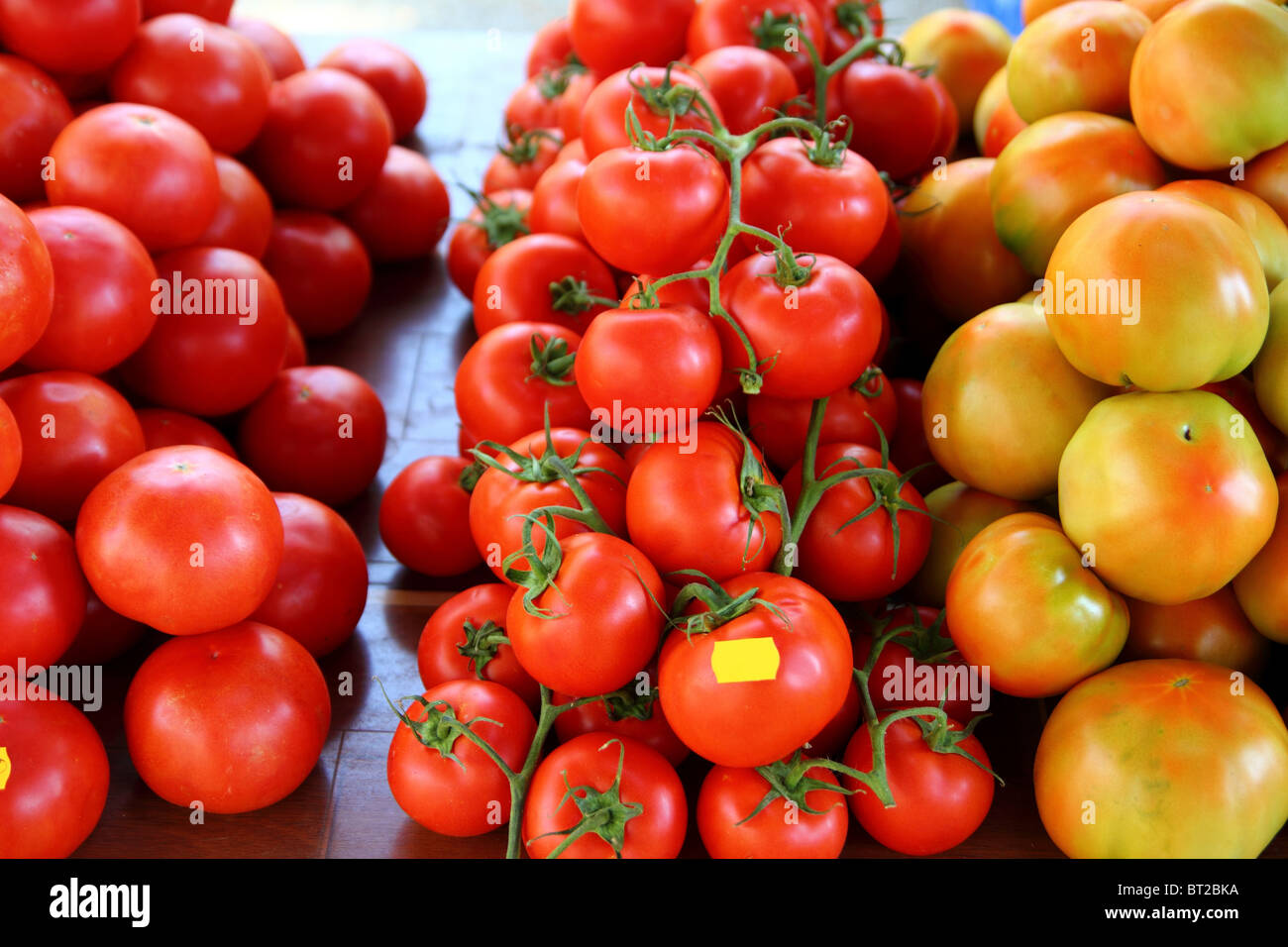 Los tomates apiladas en diferentes especies vegetales del mercado Foto de stock
