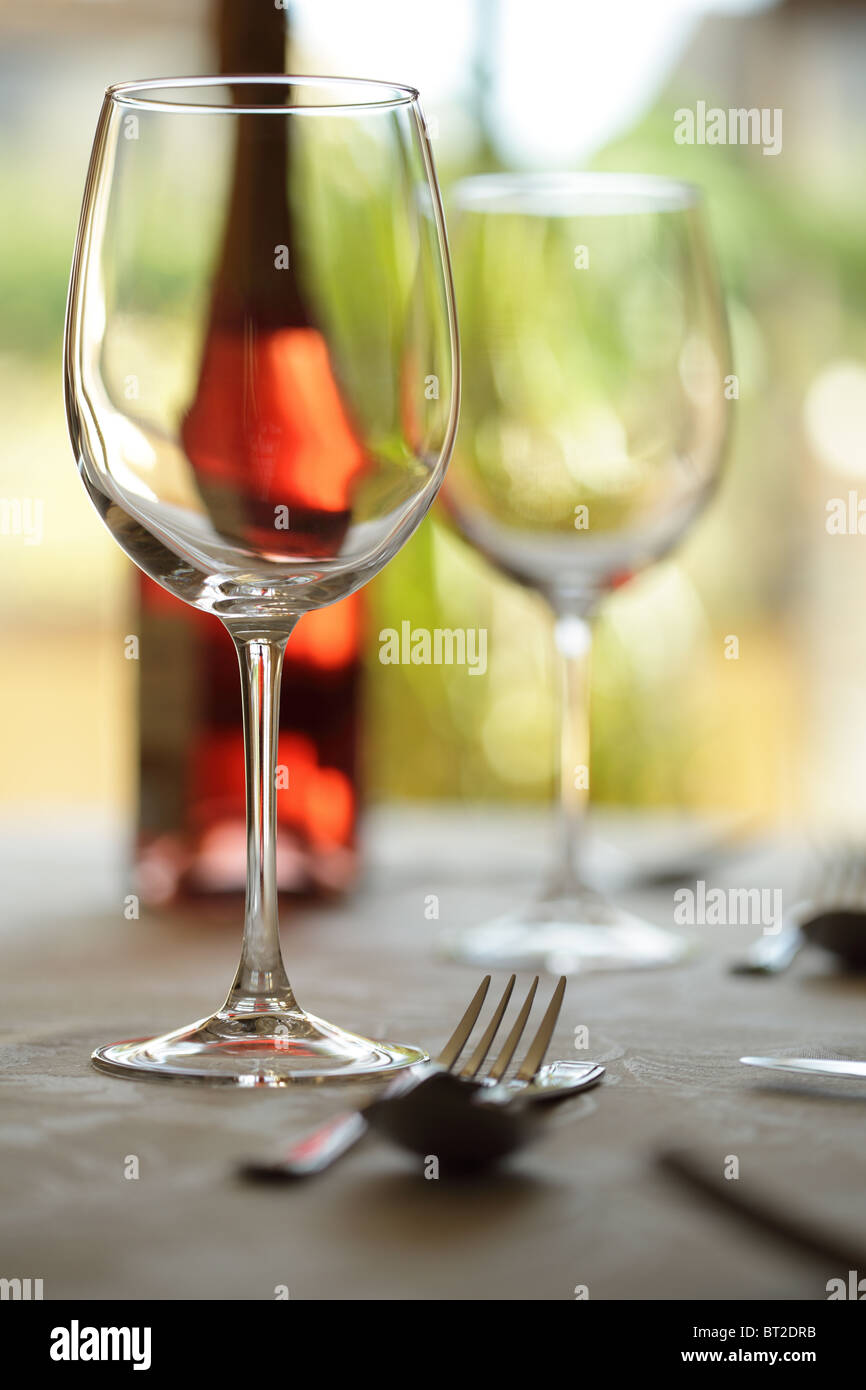 Mesa de restaurante con servicio de mesa, vino y copas de vino Foto de stock