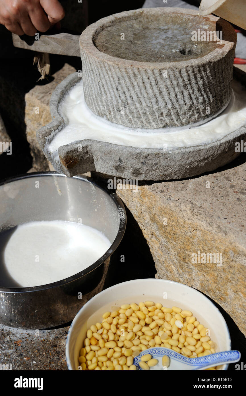 El Chino tradicional forma de hacer leche de soja es utilizar una piedra esmeriladora de grano. Foto de stock