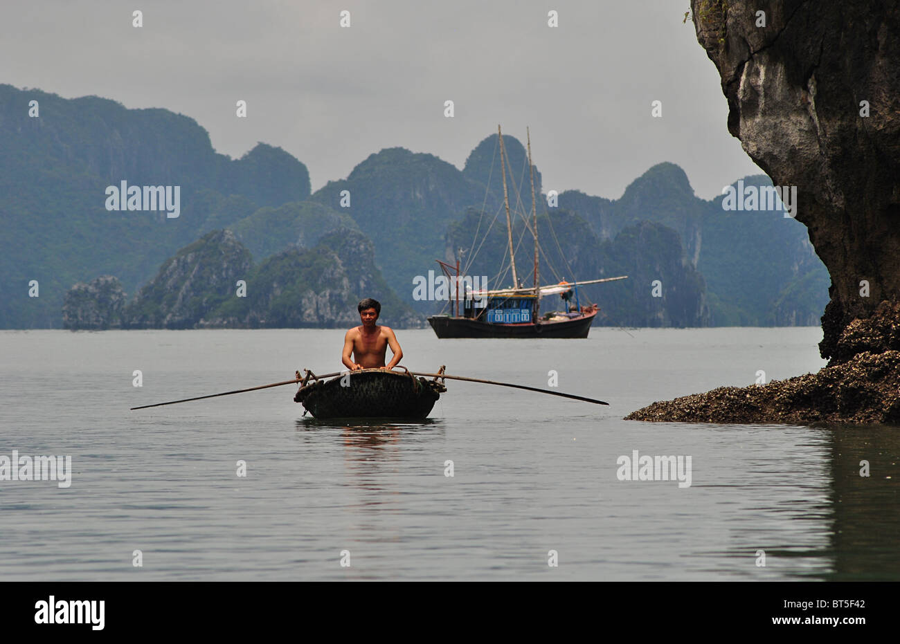 Basura y bote de remos en la Bahía de Halong, Vietnam Foto de stock