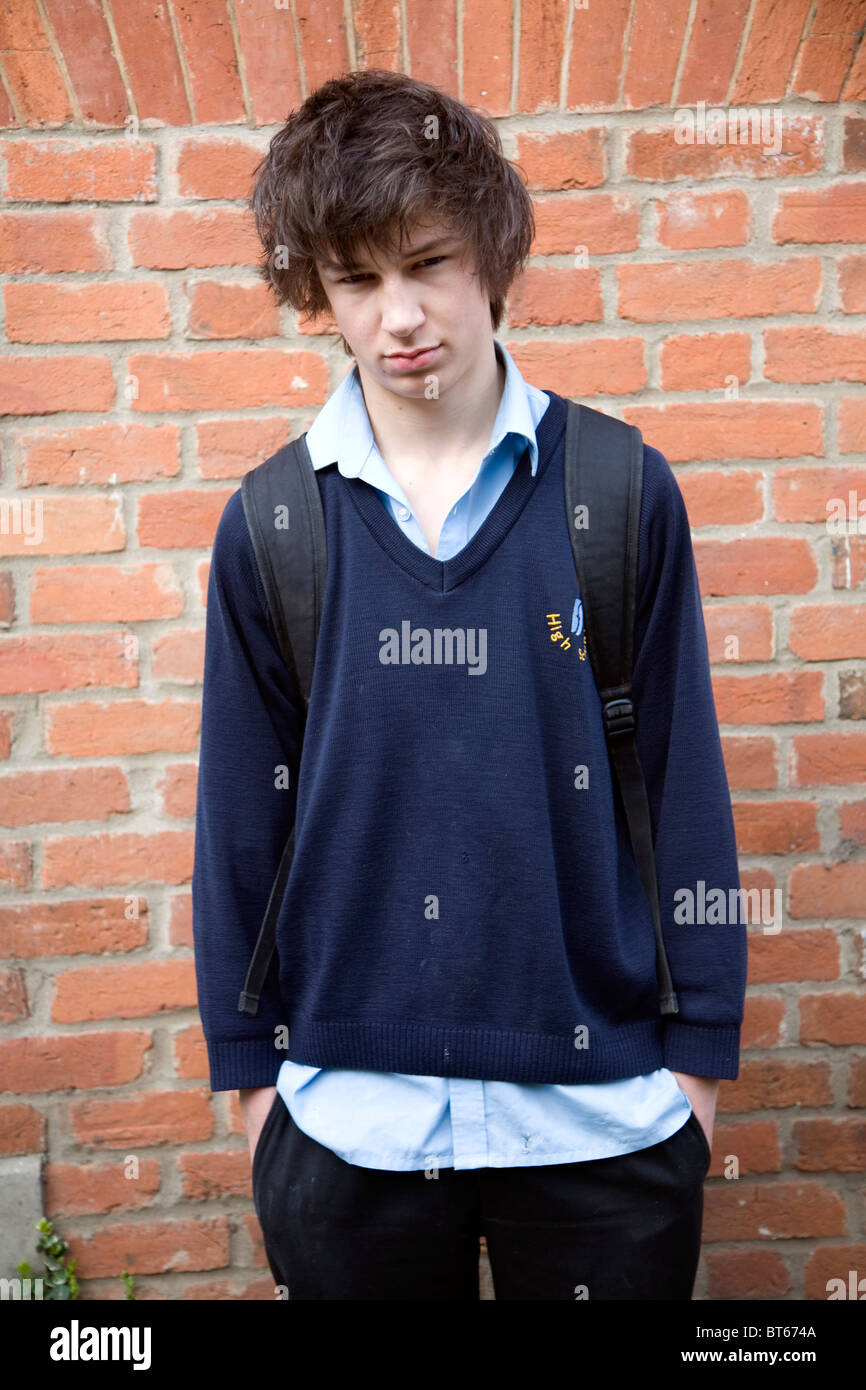 Adolescente vistiendo uniforme escolar azul marino camiseta colgando Foto de stock
