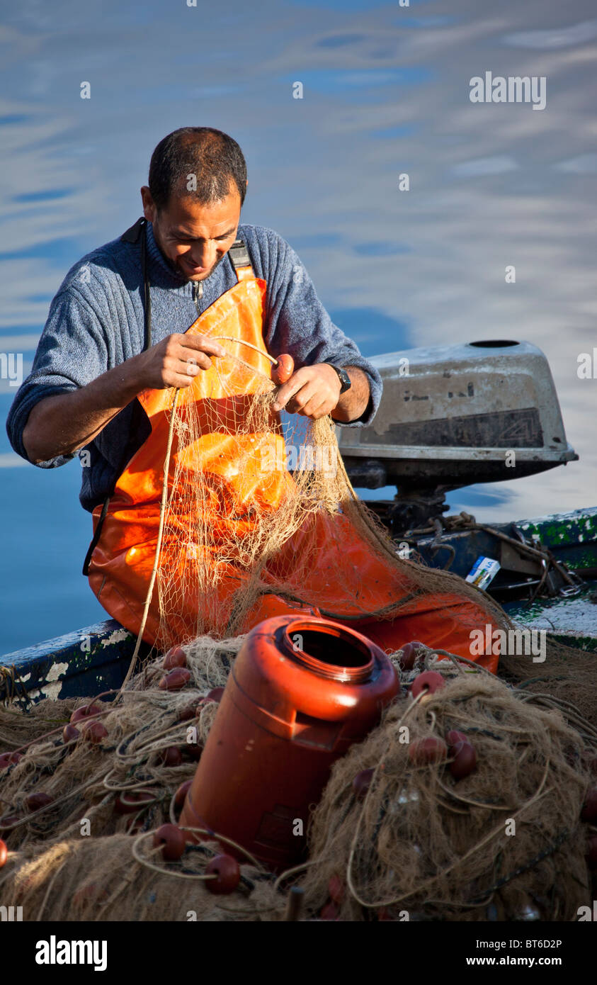 Pescador trabajando en sus redes, Siracusa, Sicilia, Italia Foto de stock