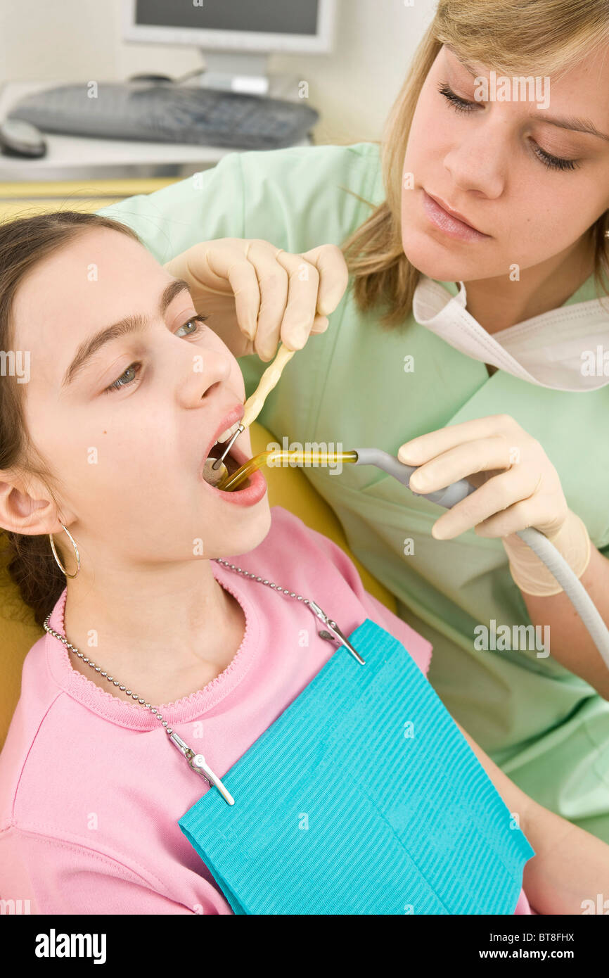 Enfermera Dental comprobando los dientes de una niña Foto de stock