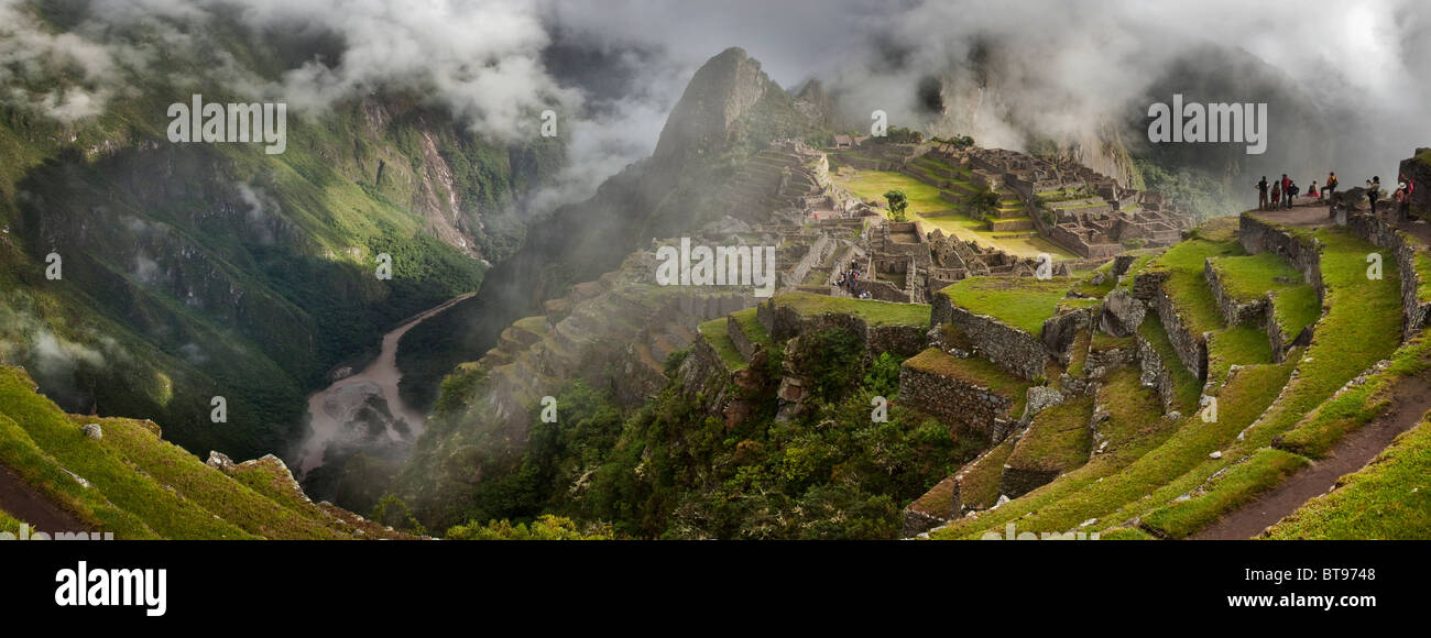 Las nubes y la niebla matutina revelan la ciudadela de Machu Picchu, la antigua "ciudad perdida de los Incas", CA 1400. Río Urubamba en la distancia. Foto de stock