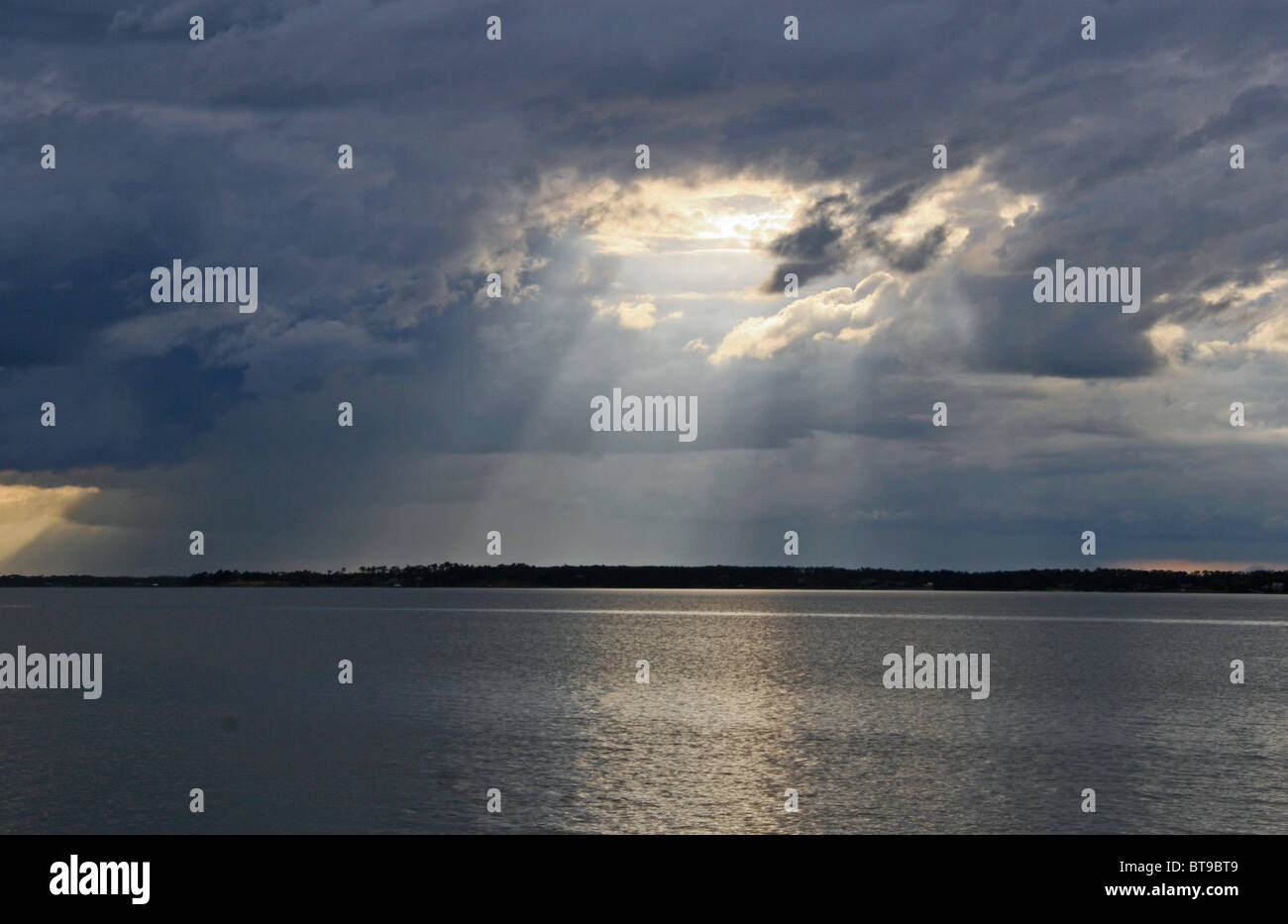 Impresionante sun ray a través de nubes cielo tormentoso sobre el agua de la Bahía de Pensacola, Florida cielo Perdido Key apertura Foto de stock