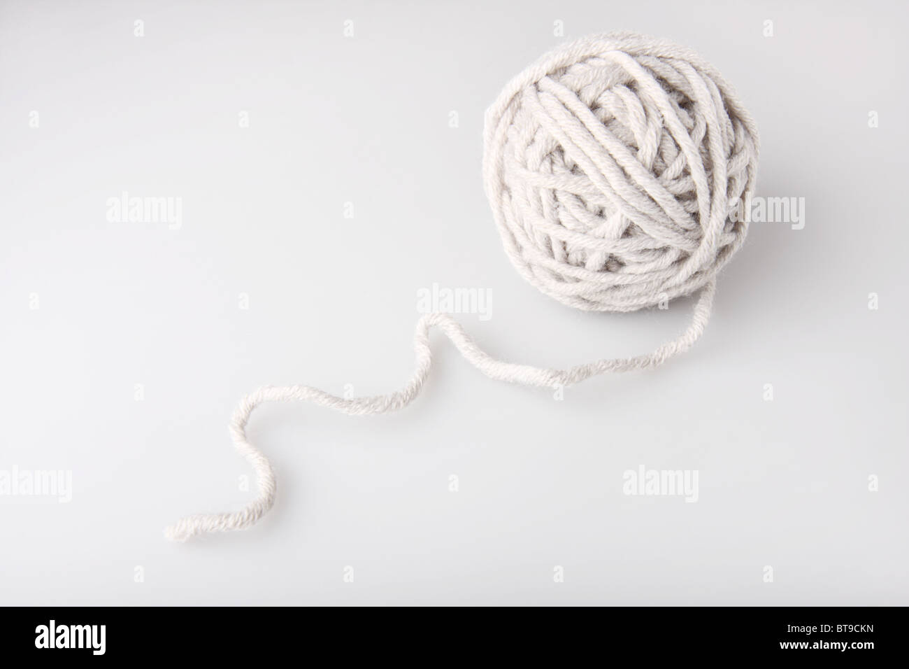 Clew de hilados de lana gris sobre el fondo neutro Foto de stock