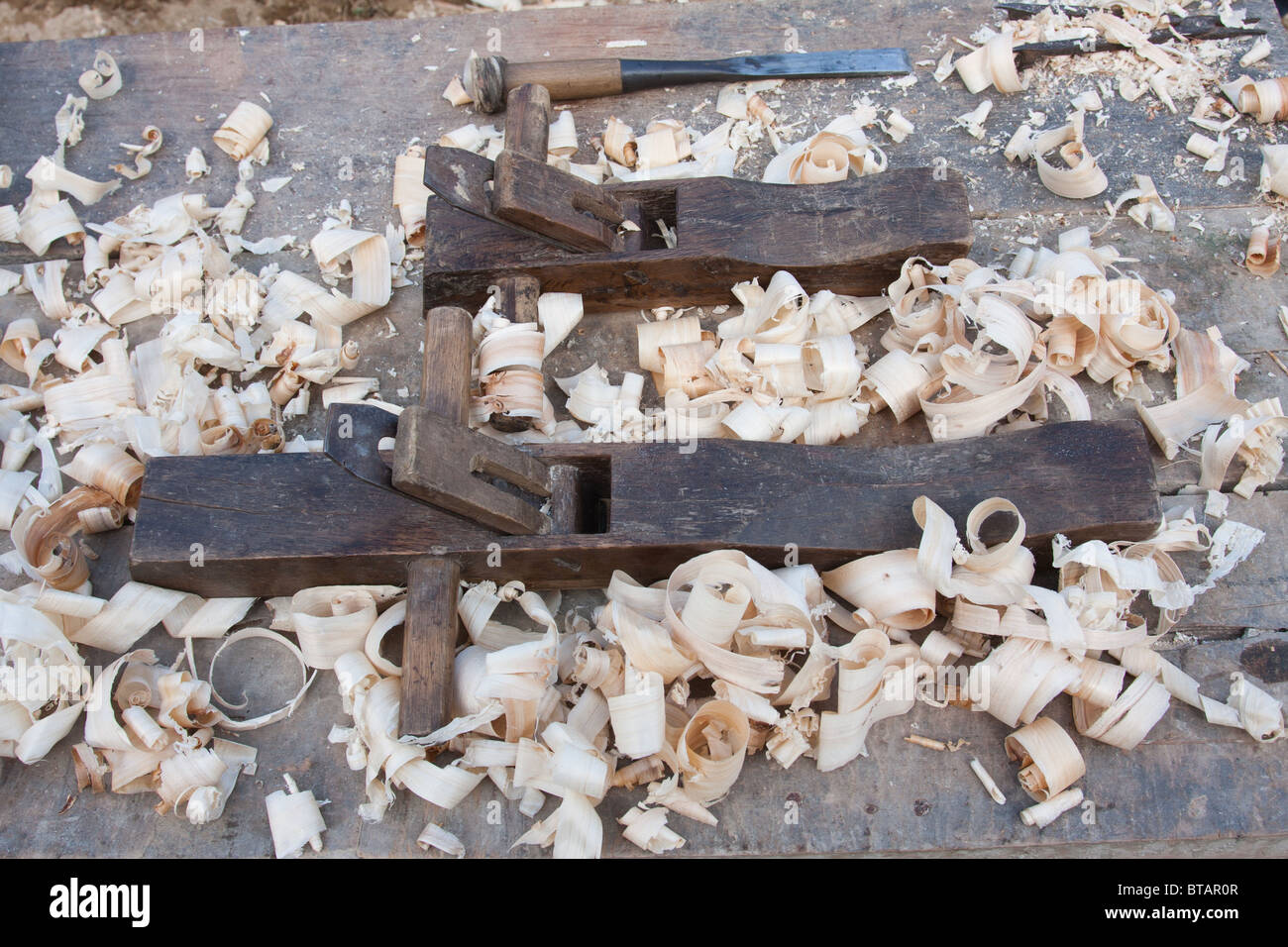 Las herramientas de la carpintería primitivos junto con virutas de madera sentarse en una mesa en la zona rural de la provincia de Yunnan, China Foto de stock