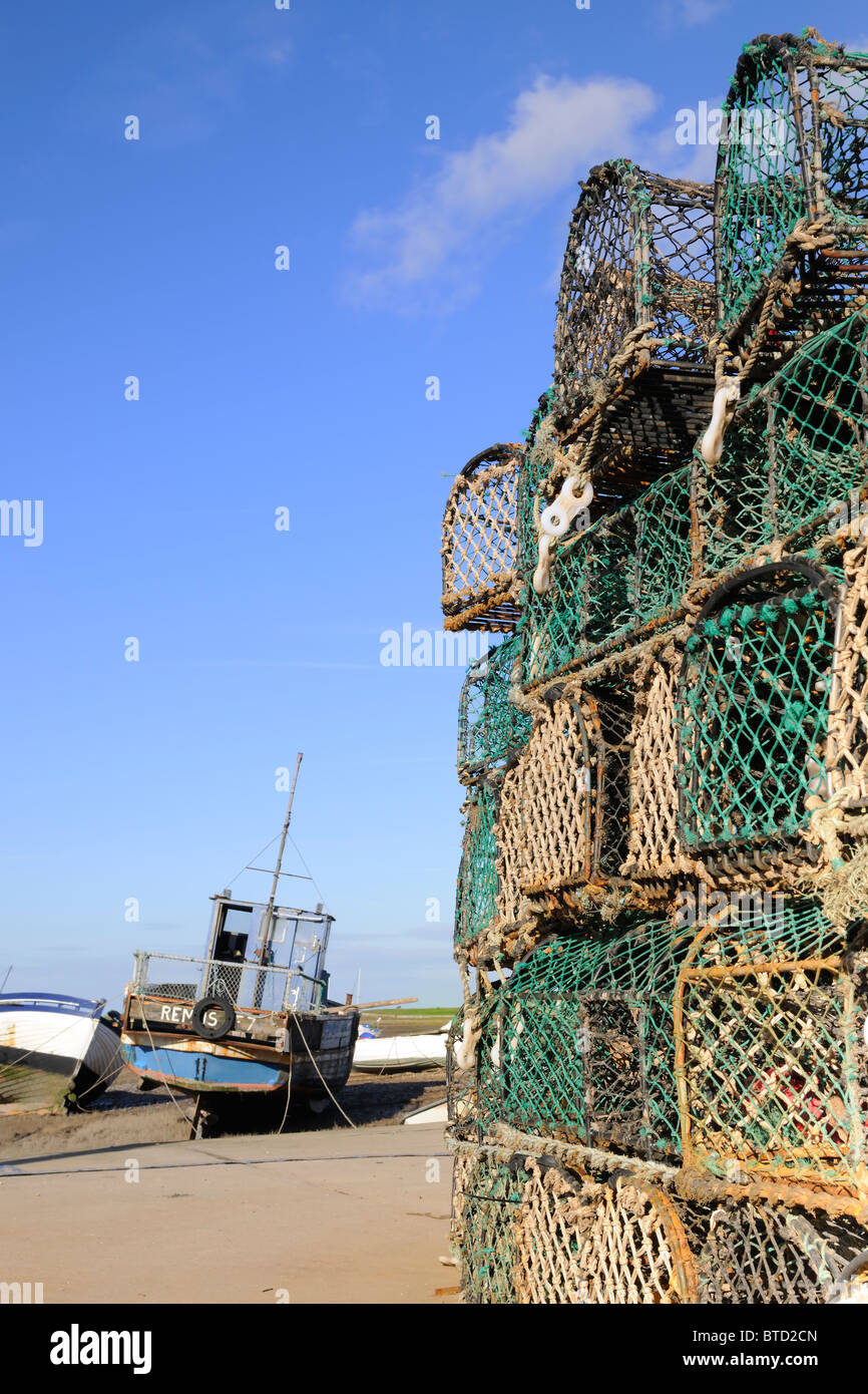 Un barco de pesca amarrados enmarcado por la langosta en Brancaster Staithe Pots Foto de stock