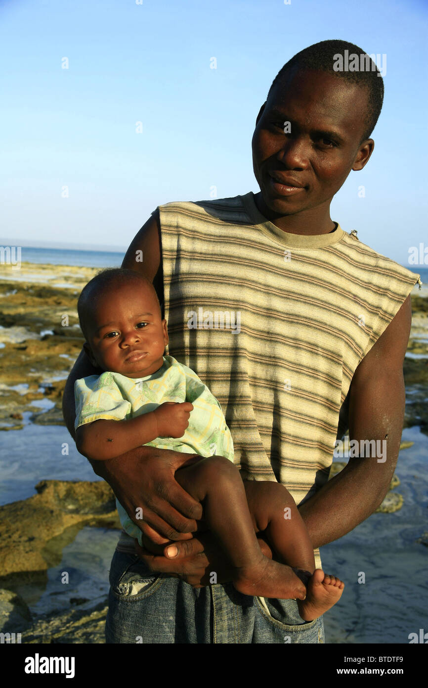 Hombre sujetando un bebé negro Fotografía de stock - Alamy
