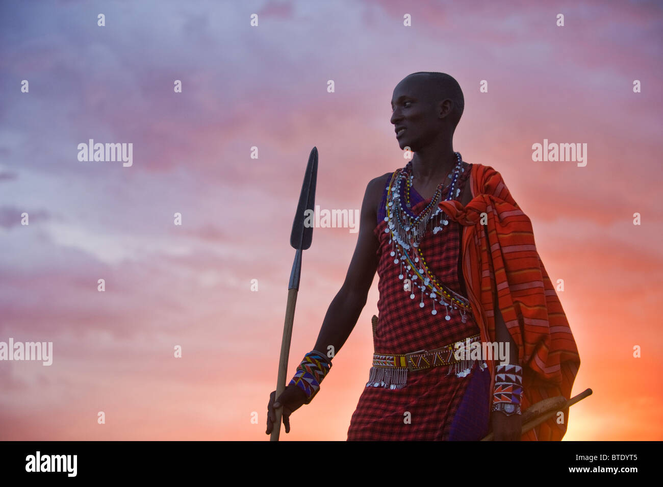 Maasai moran o guerrero con lanza contra la puesta del sol Foto de stock