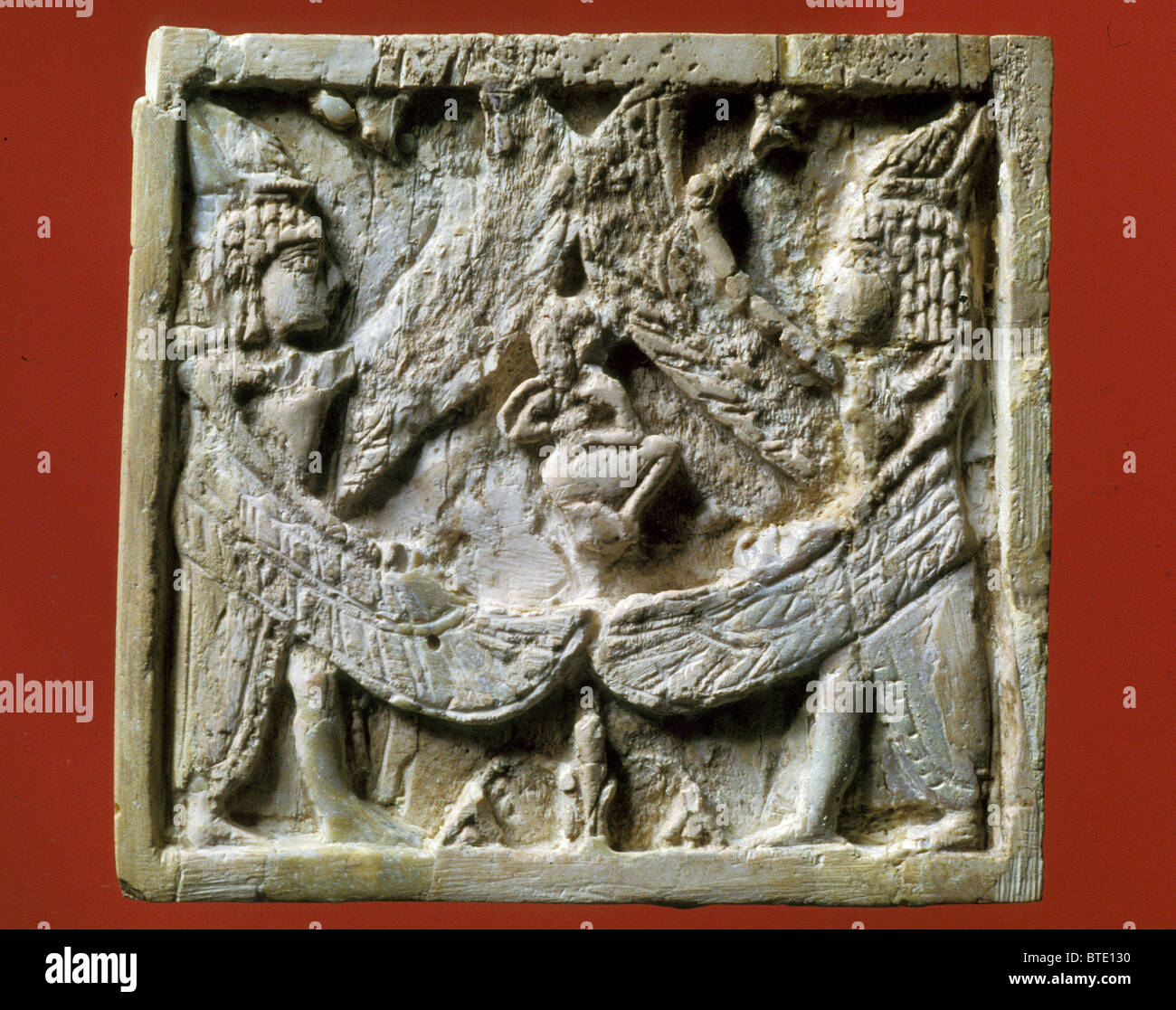 4B. Placa de marfil representando dos criaturas aladas albergando a una persona. Siria; Arslan Tash, 8ª. C. A.C. se situó "por encima de la Foto de stock