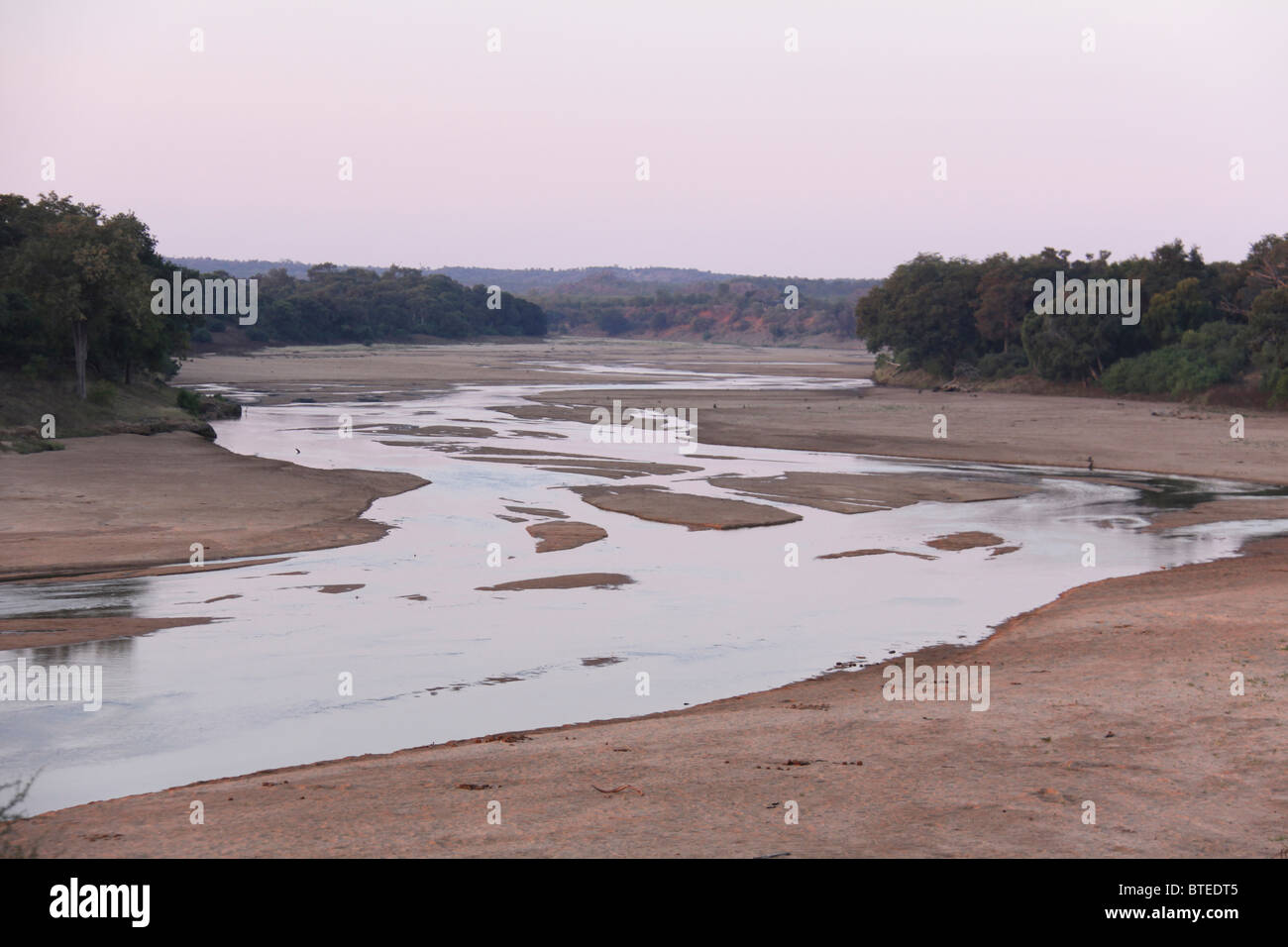 Mwenezi lecho del río sinuoso con árboles a ambos lados de los bancos Foto de stock