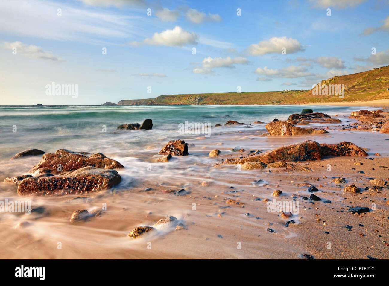 La vista al norte de Whitesands Bay cerca del Cornwall Sennen Cove capturó utilizando una velocidad de obturación lenta para difuminar el receeding olas. Foto de stock