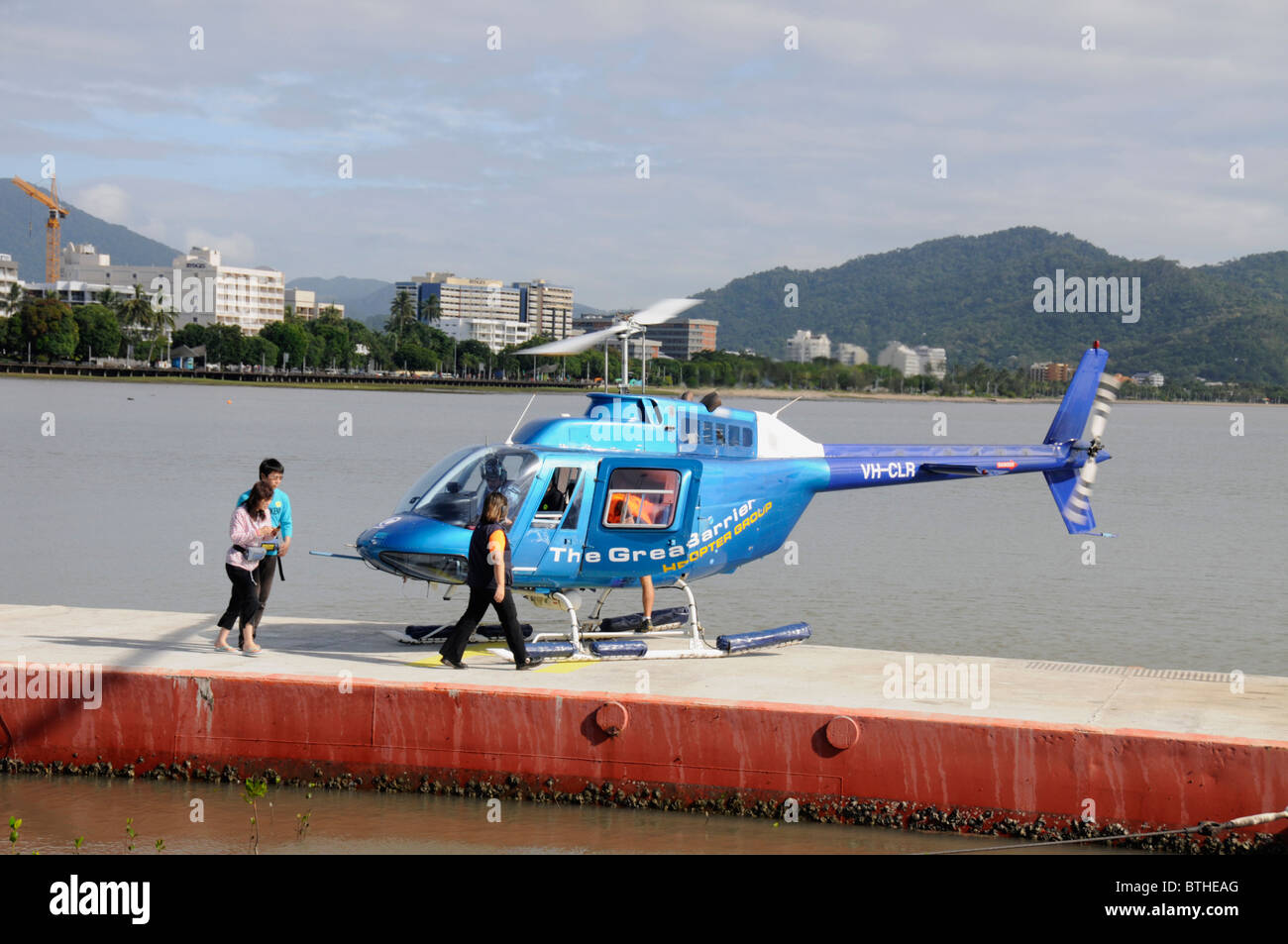 Un grupo de turistas suben a bordo de un helicóptero en Cairns para tomar un vuelo a Green Island, Queensland, Australia Foto de stock