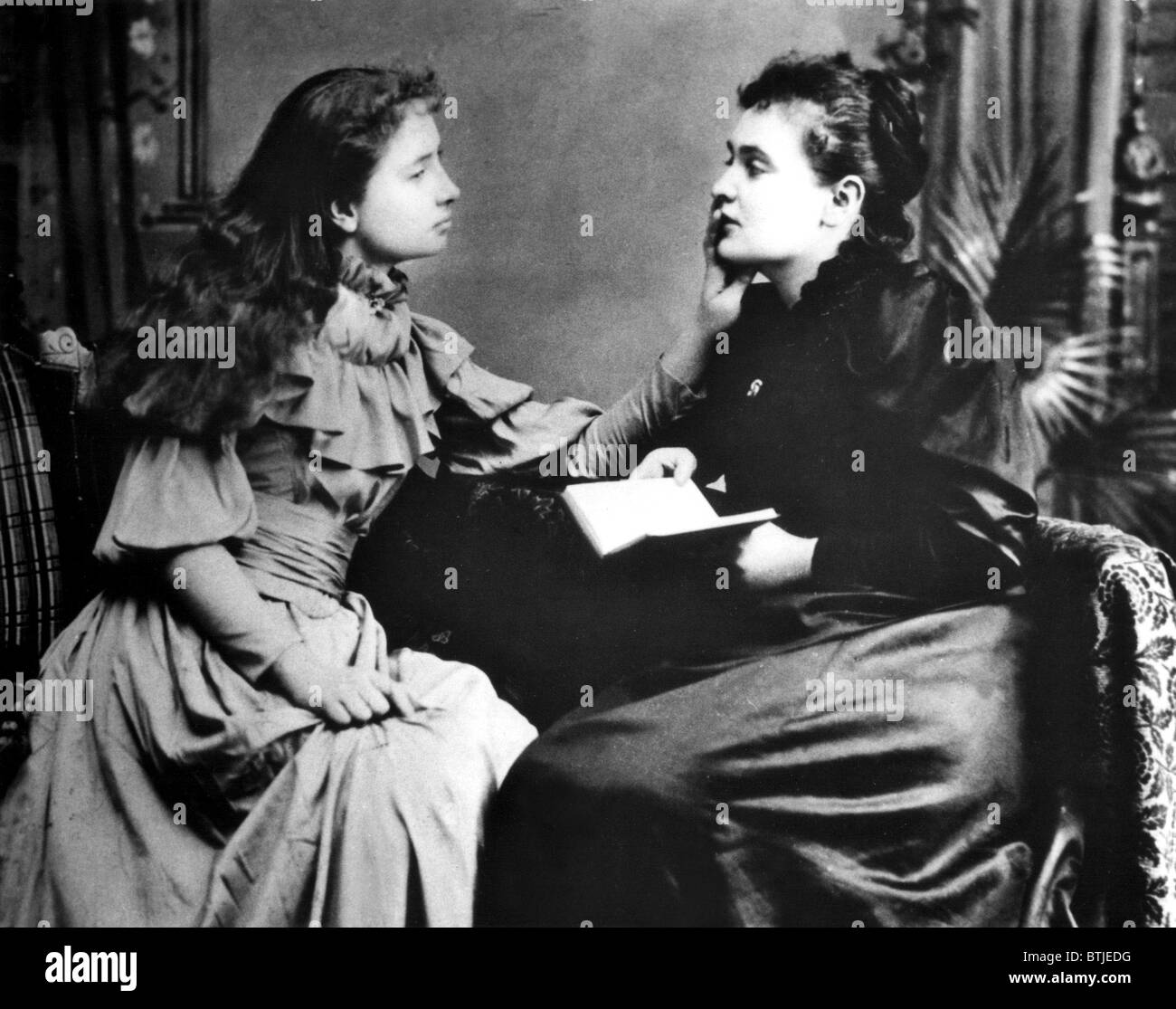 Foto ilustra cómo Helen Keller (izquierda) 'escucha' su instructor, Anne Sullivan al sentir las vibraciones de sus labios. Foto de stock