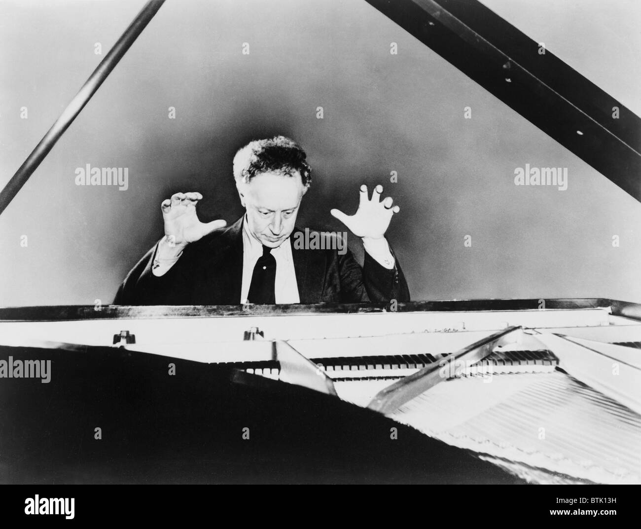 Artur Rubinstein (1887-1982), un piano de cola, con las manos levantadas en 1961. El pianista polaco se convirtió en ciudadano estadounidense en 1946. Foto de stock