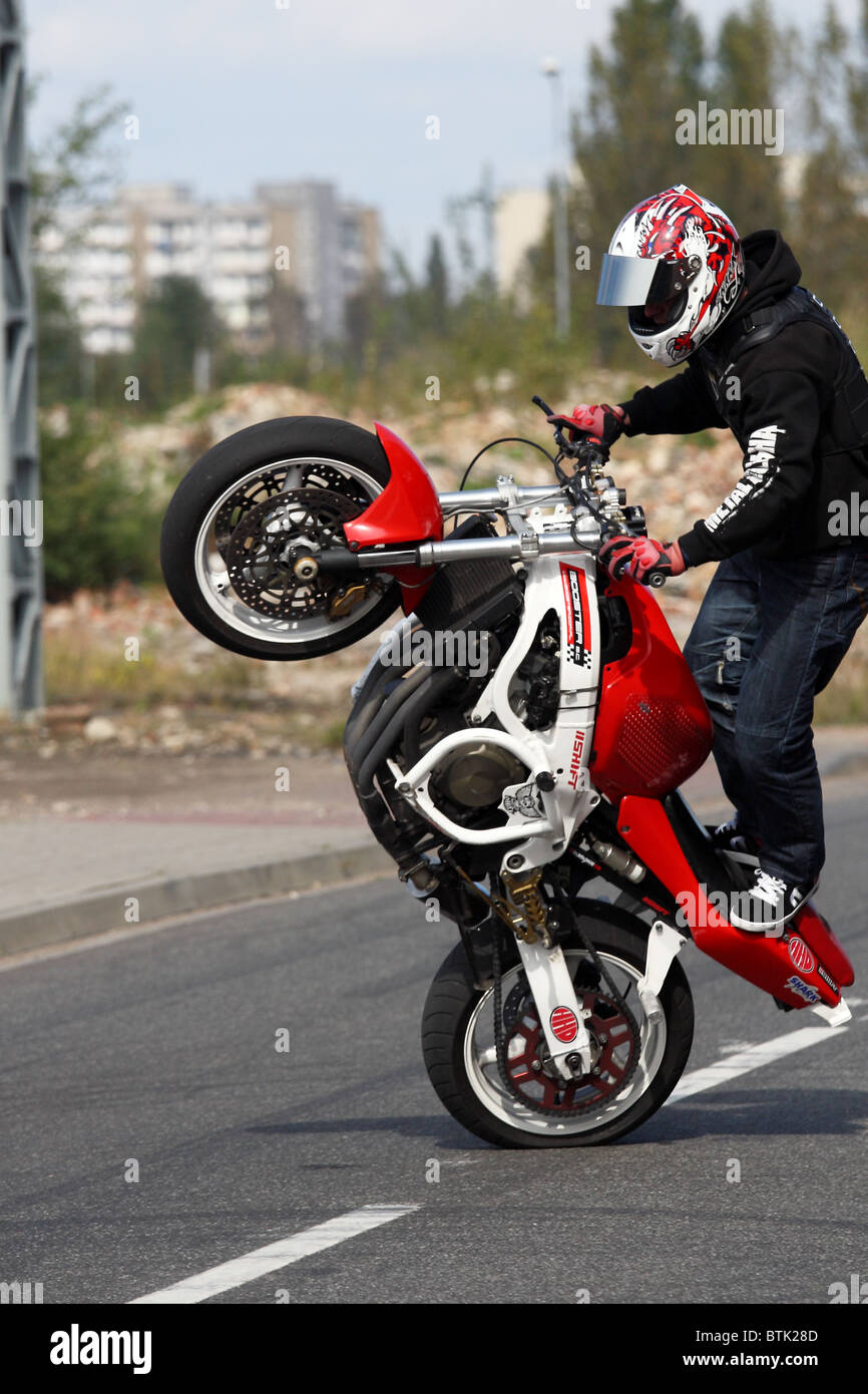 Stunt motorbiker equilibrio sobre su moto Honda sobre la rueda trasera  Fotografía de stock - Alamy