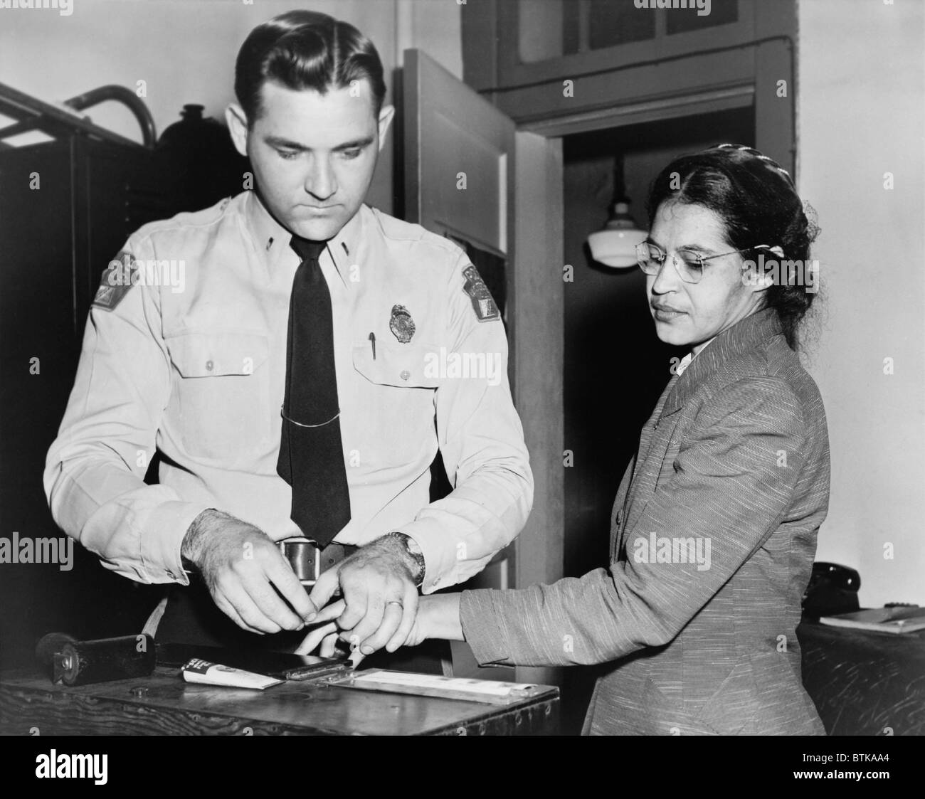 Rosa Parks (1913-2005), cuya negativa a desplazarse a la parte posterior de un autobús que desencadenó el boicot de autobuses en Montgomery, Alabama. El fingerprinting Parques es el Sheriff D.H. Lacayo. El 1 de diciembre de 1955. Foto de stock
