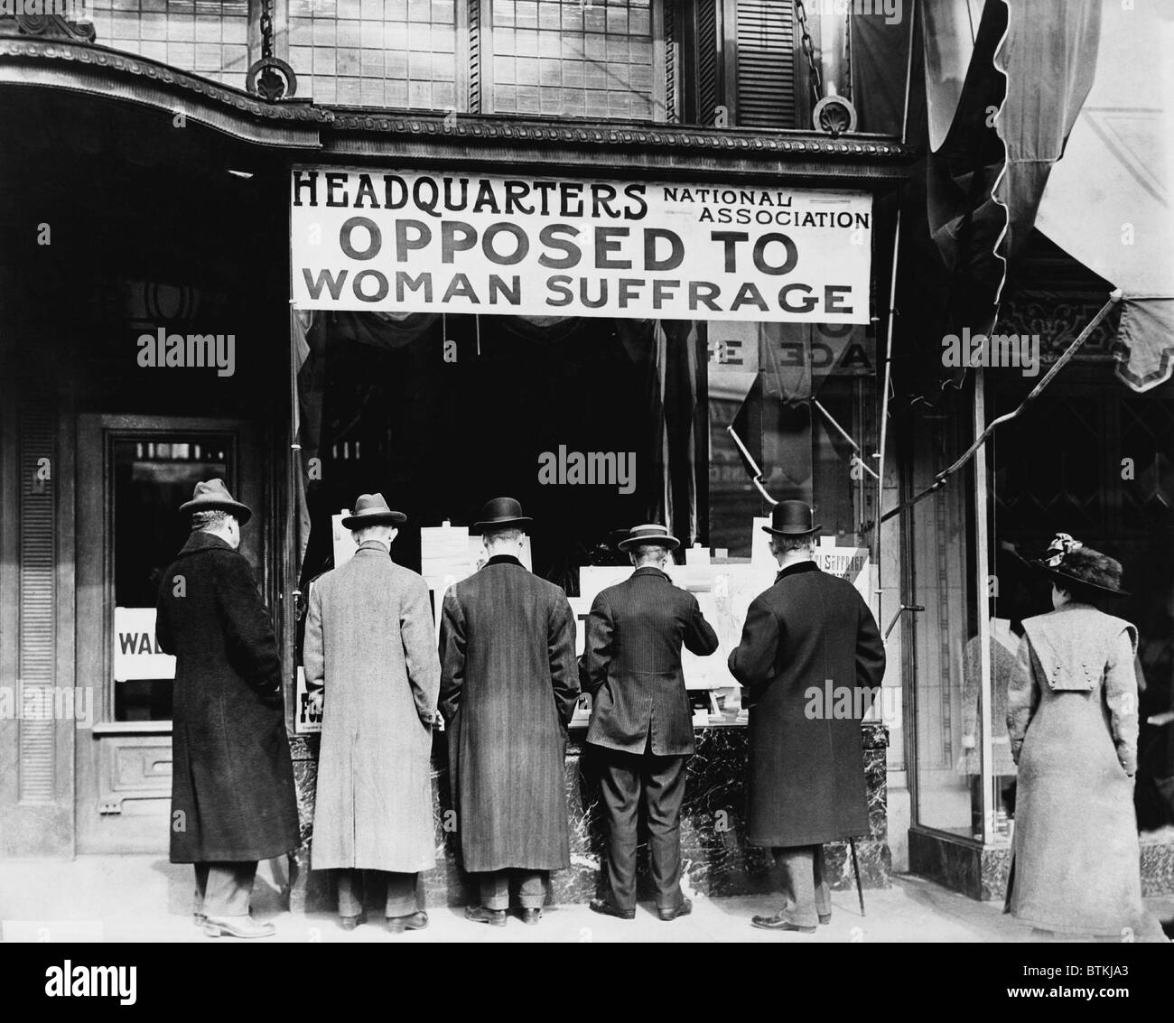 Hombres que buscan en la ventana de la sede de la asociación National Anti-Suffrage, Asociación Nacional de Oposición al sufragio femenino estaba activa en el estado y a nivel nacional a fin de impedir la aprobación de una enmienda federal del sufragio de la mujer. Ca. 1911. Foto de stock