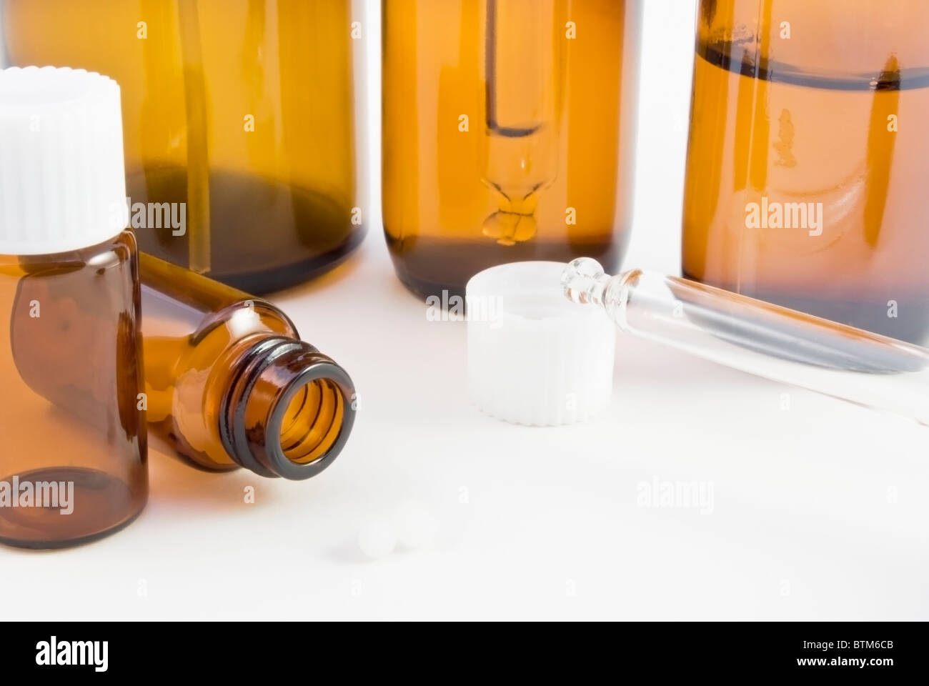 Una colección de botellas de vidrio ámbar remedy (spray, gotero y píldora) y pillules utilizadas en farmacia homeopática. Foto de stock