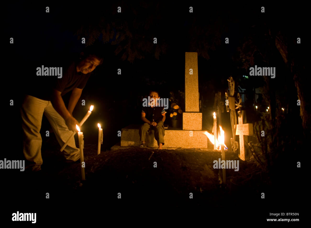 Un hombre enciende una vela en una tumba Como su nieto de relojes en el  cementerio de San Gregorio Atlapulco, Xochimilco, Ciudad de México  Fotografía de stock - Alamy