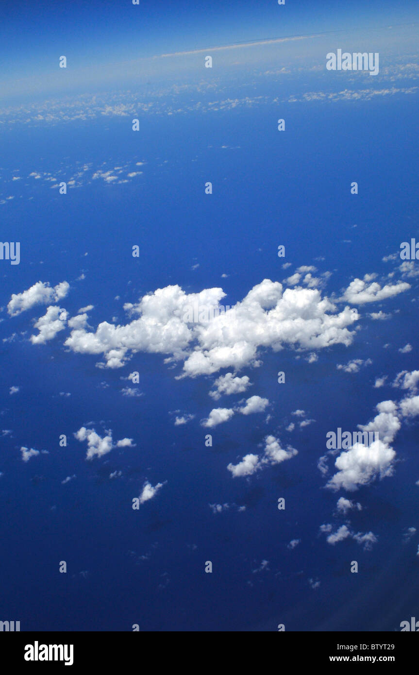 Una vista de las nubes debajo tomadas desde un avión. Por debajo de las nubes está el mar. Foto de stock