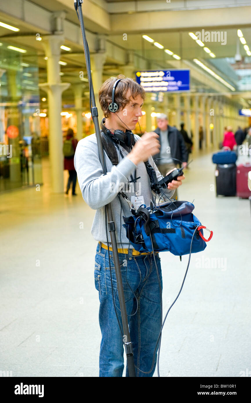 London St Pancras Station ingeniero de sonido joven se prepara para el lanzamiento de un programa de televisión para preguntar al médico desde la parte inferior de la calzada Foto de stock