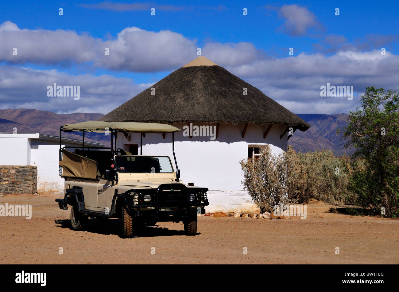 Un Safari Jeep estacionado en frente de una cabaña de estilo africano. Sudáfrica. Foto de stock