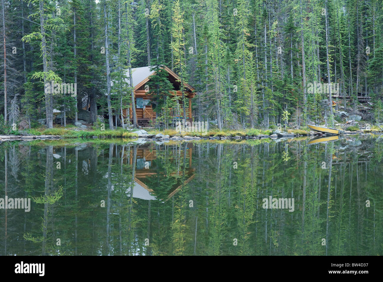 Una cabaña está ubicado a lo largo de las orillas de un tranquilo lago desierto Foto de stock