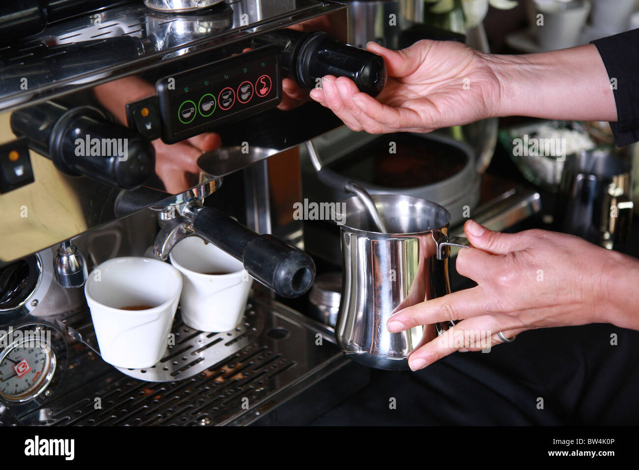 Utilizando una máquina para hacer café leche espumosa para un capuchino