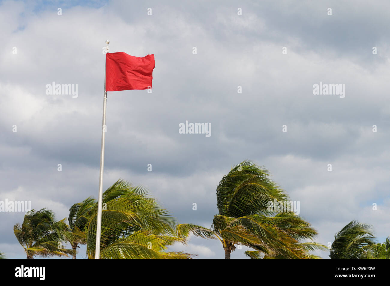 Precaución bandera roja en una playa del Caribe durante los vientos fuertes desde el próximo huracán Tomas Foto de stock