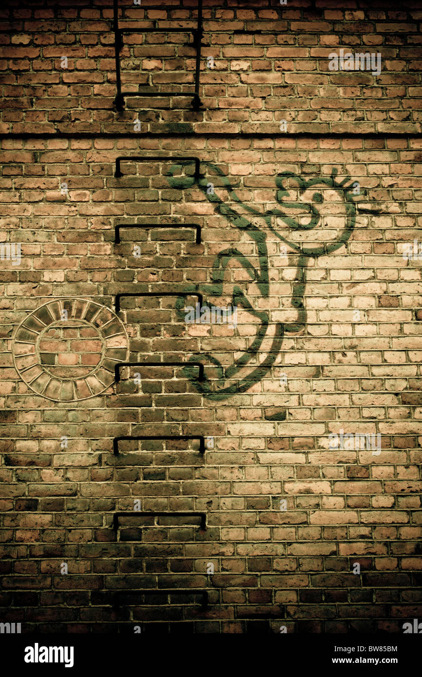 Graffiti en pared de ladrillo con pasos de metal Foto de stock