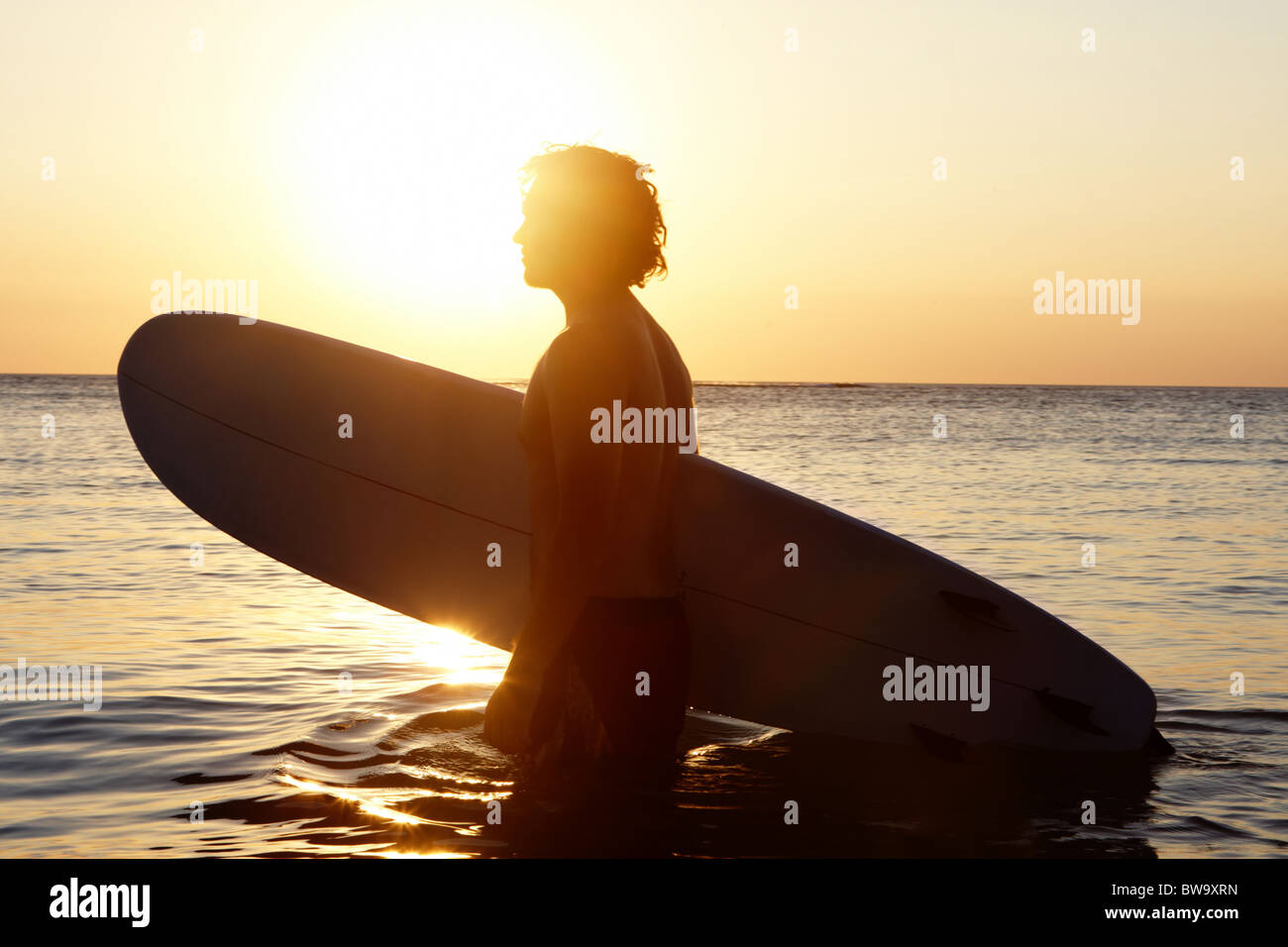 Retrato de joven en agua con windsurf al atardecer Foto de stock