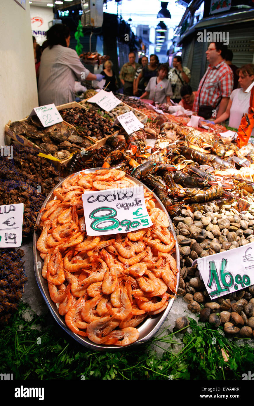 Placa con 'cocido' de gambas, camarones, a la venta en stand de mariscos en el mercado de la Boqueria hall, en Barcelona, España Foto de stock