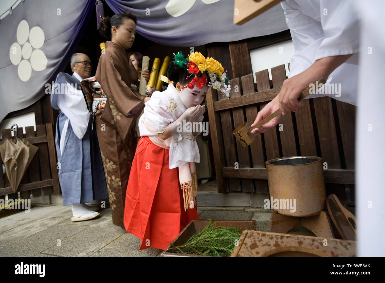 Pequeña niña japonesa de lavarse las manos en preparación para el Matsuri festival en Kitano Tenman-gu santuario en Kioto, Japón. Foto de stock