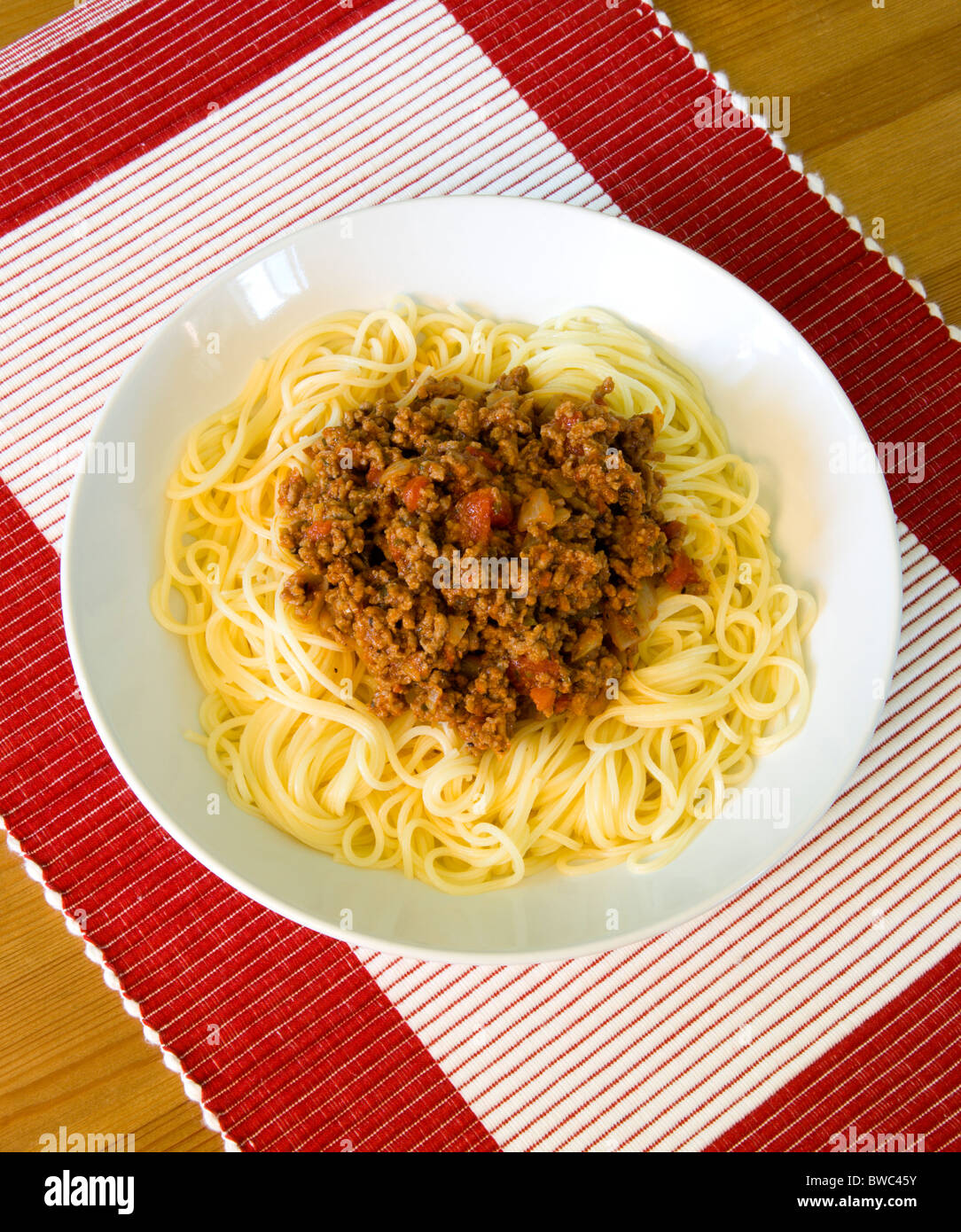 Comida, cocinada, pasta, espaguetis a la Boloñesa en un recipiente sobre una mesa. Foto de stock