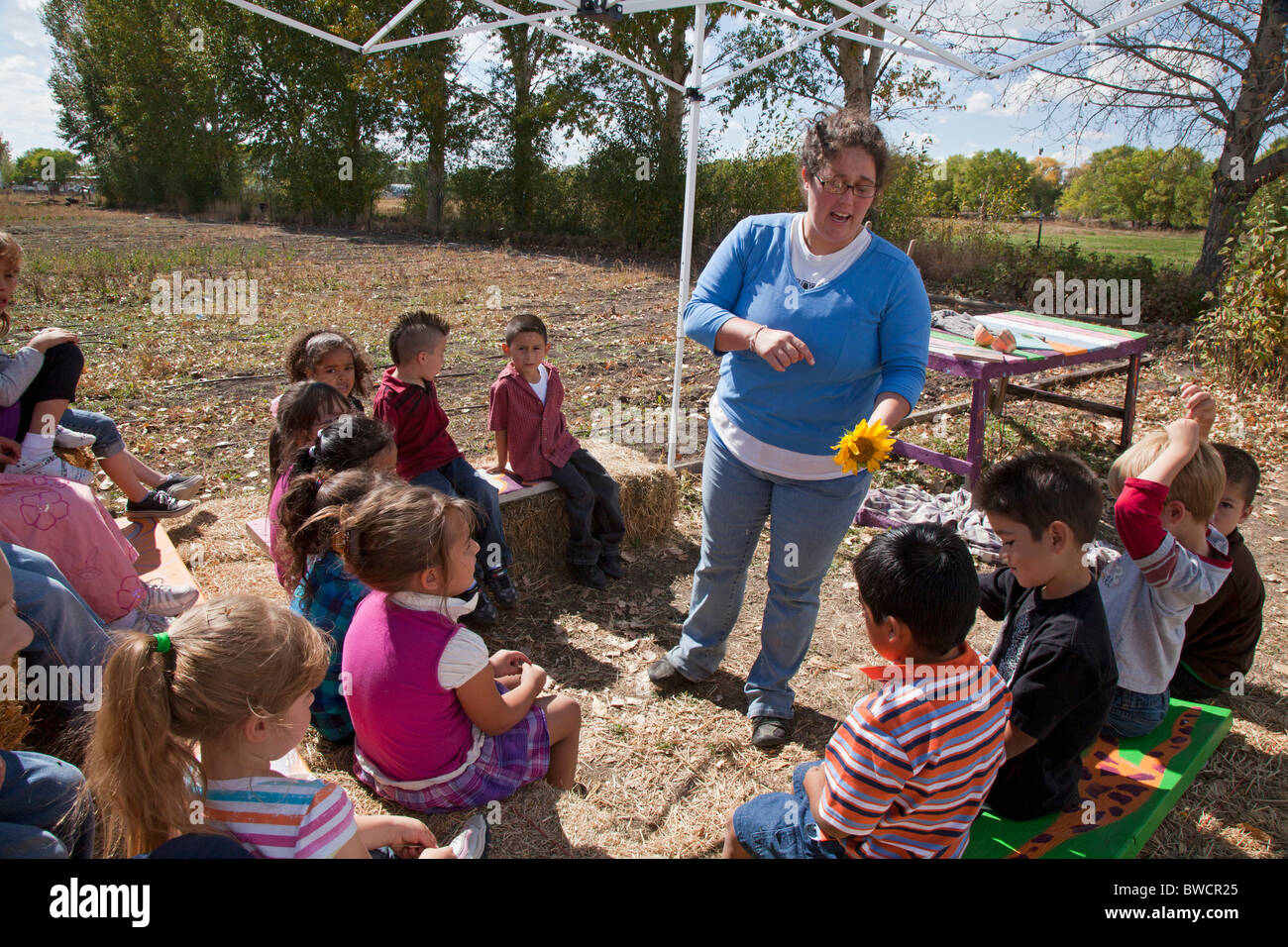 Voluntarios de Americorps charlas a los niños de escuela primaria en el jardín de comunidad Foto de stock