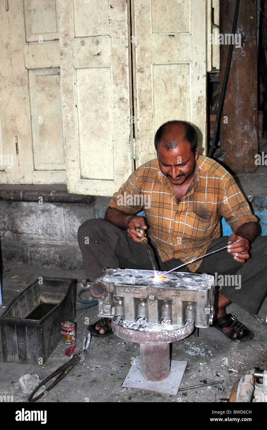 Hombre indio reparación alquiler de bloque motor con culata de soldadura  usando un soplete de gas, pero no el uso de las gafas de seguridad  Fotografía de stock - Alamy