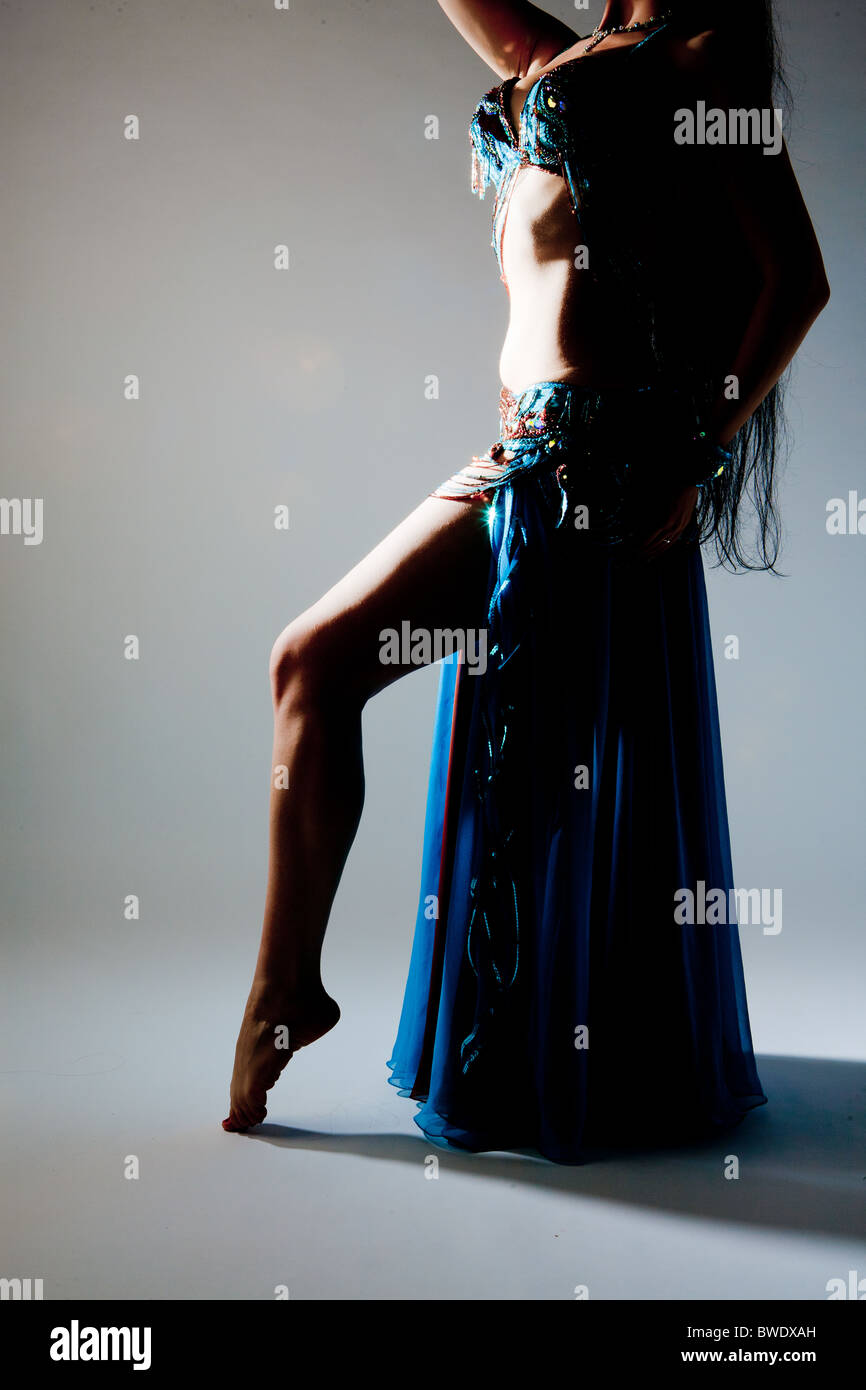 Mujeres Sexy bellydancer con largo cabello negro mostrando traje azul y oro  Fotografía de stock - Alamy