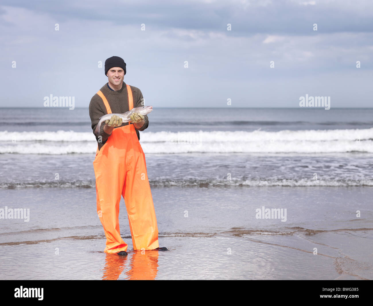 Pescador en la orilla la celebración de pescado Foto de stock