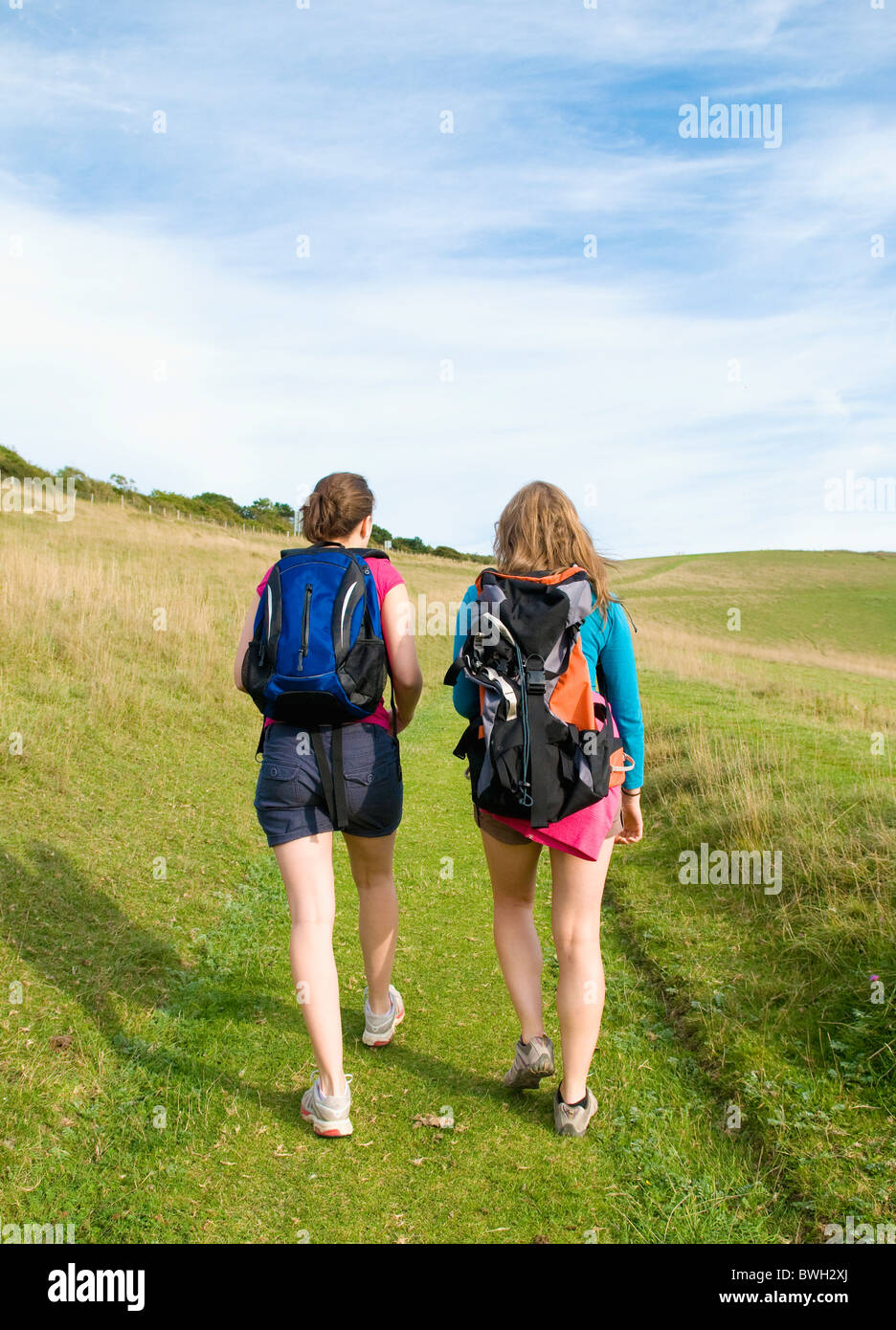 Dos jóvenes mujeres excursionistas subir cuesta arriba Foto de stock