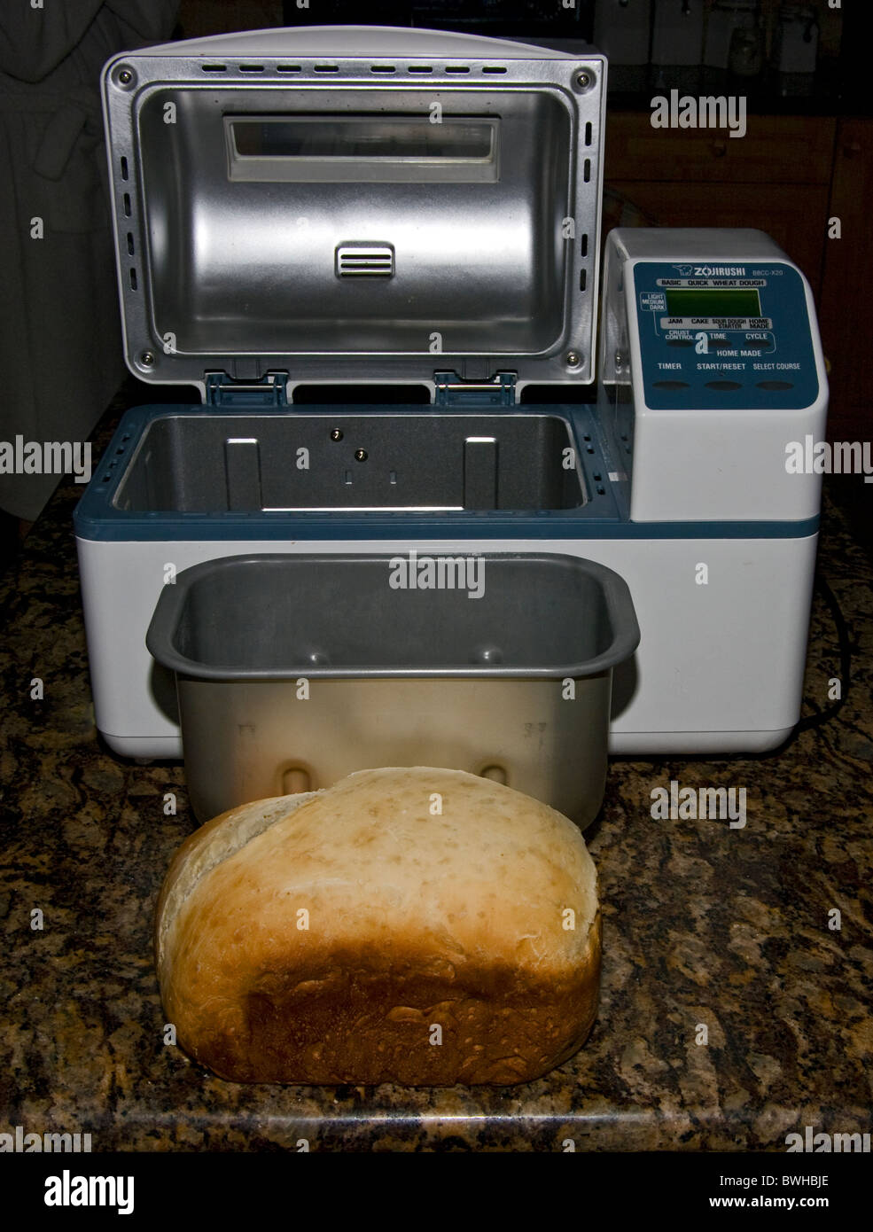 Con bandeja de hornear pan Maker y una hogaza de pan fresco Foto de stock
