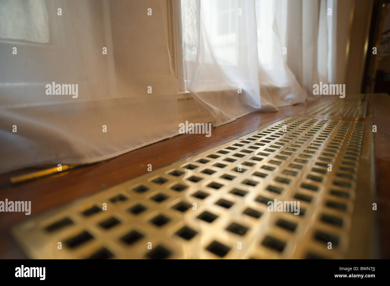 La parrilla del radiador victoriano cubre contra la ventana con cortinas  calefacción central Fotografía de stock - Alamy