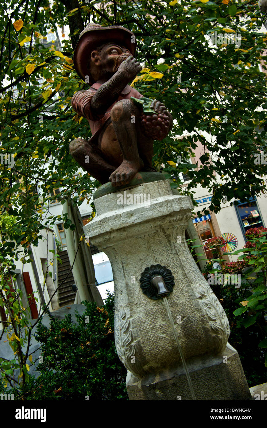 Whimsical vistiendo mono hat comer fruta escultura fuente de agua potable uno de 170 en Basilea, Suiza Foto de stock