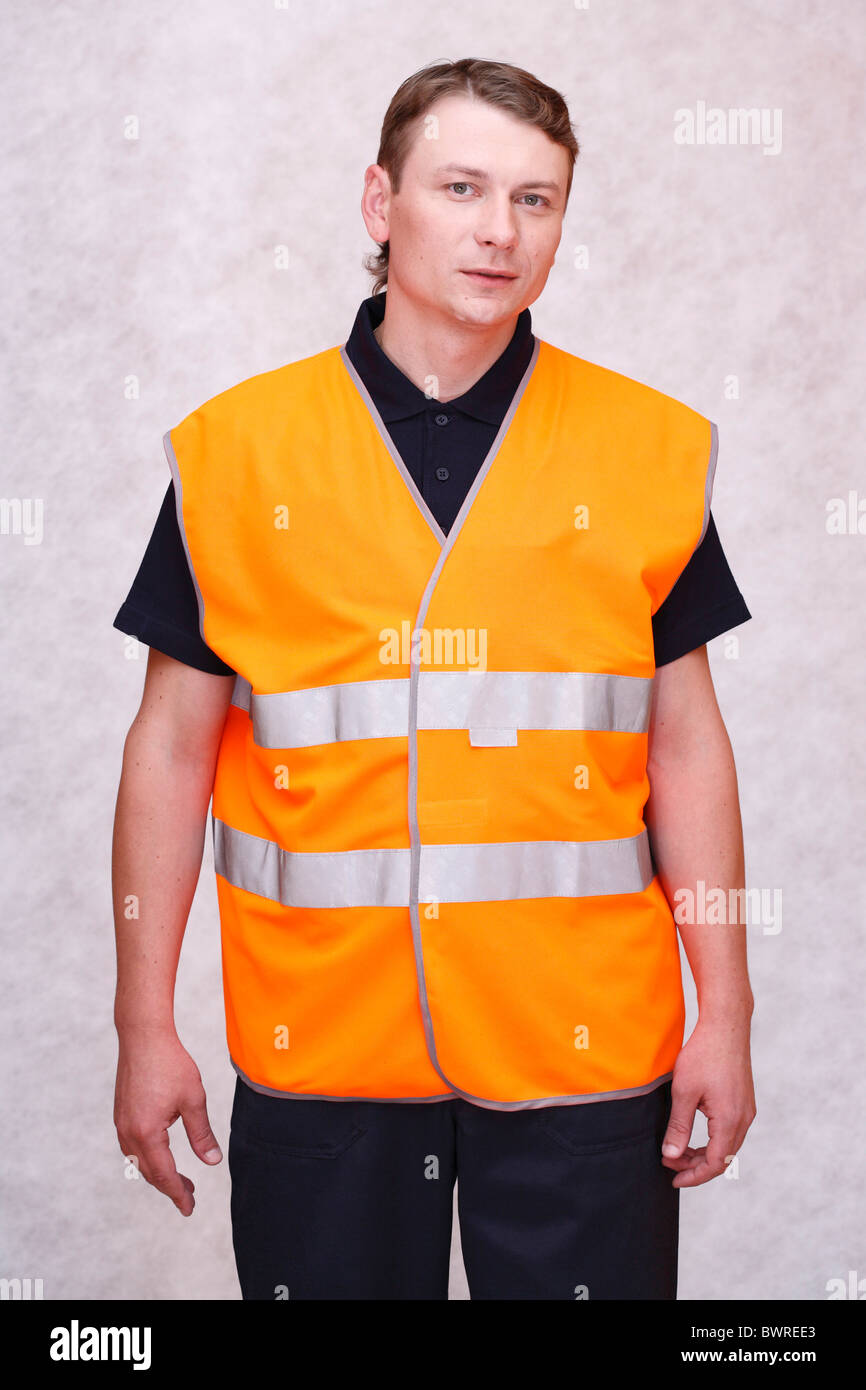 Trabajador de la carretera trabajo hombre vestido de uniforme naranja industria joven estudio ocupaciones ocupación trabajo vertical Foto de stock