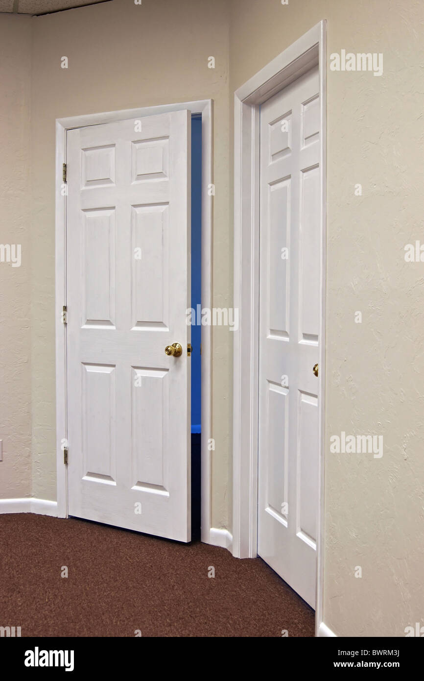 Dos puertas con blanco Brass knobs, uno se abre y el otro se abre hacia  afuera, en la puerta está ligeramente abierta Fotografía de stock - Alamy